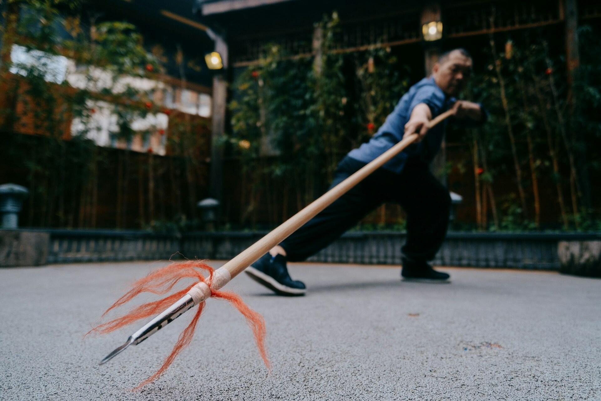 Person practicing Chinese martial arts with a long spear.