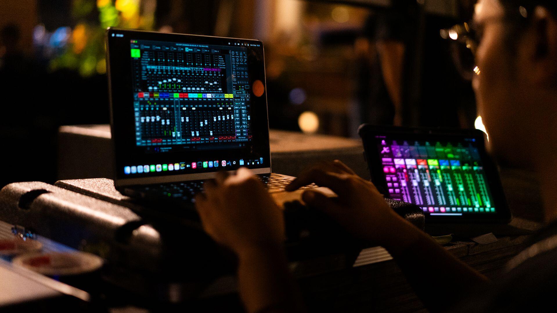a mixing engineer using DAW on a laptop computer to mix tracks