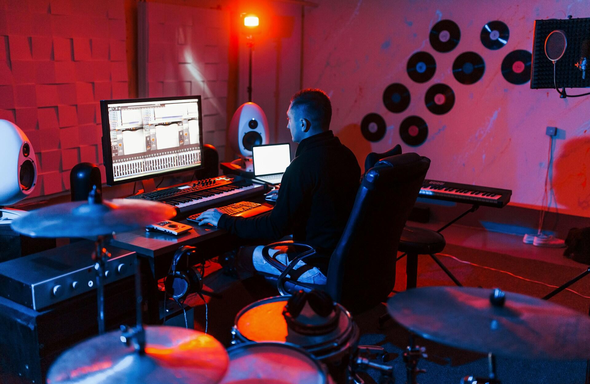 music producer in a professional recording studio with musical instruments and acoustic wall treatment