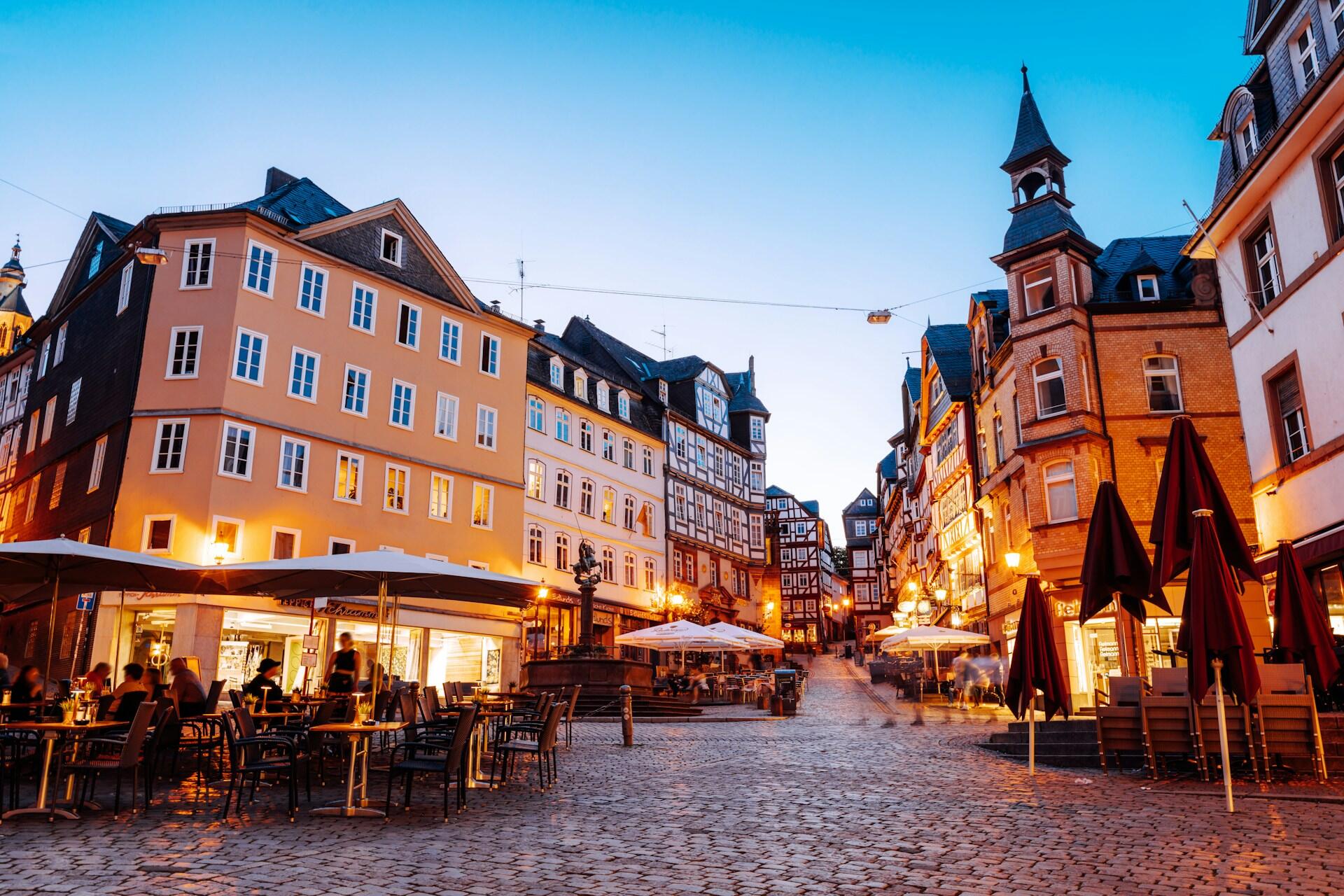Cozy German square at dusk with outdoor cafes.
