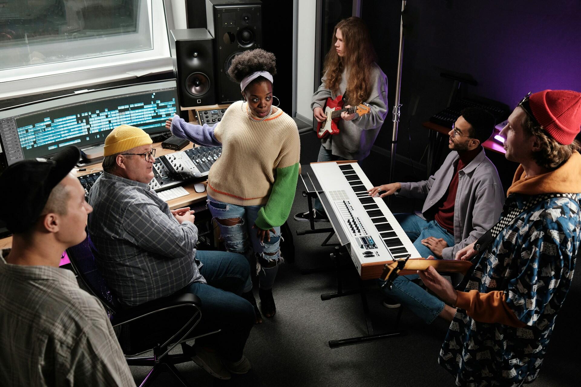 A studio manager discussing with musical artists and the recording engineer in a recording studio