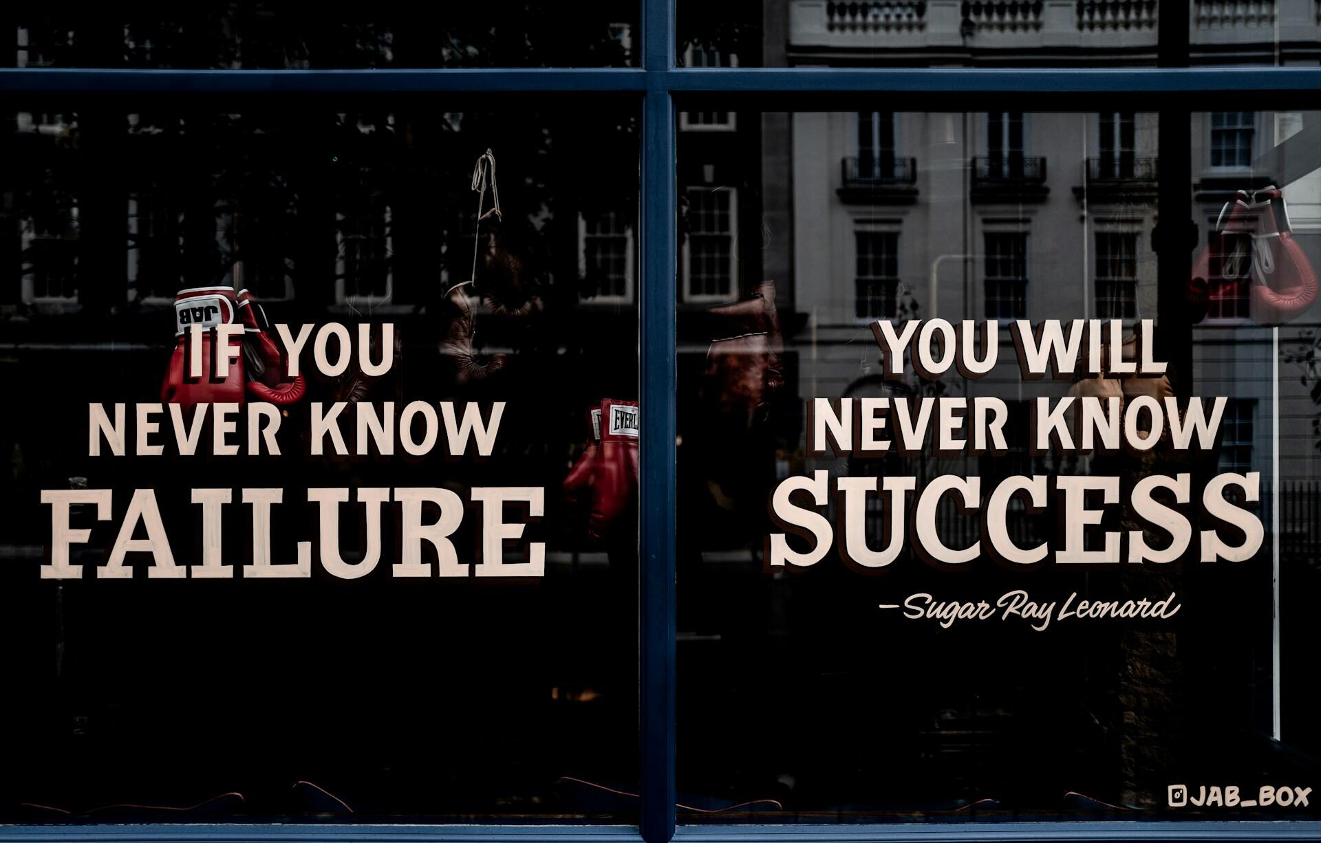 A darkened shop window features a motivational quote across its two large panes.