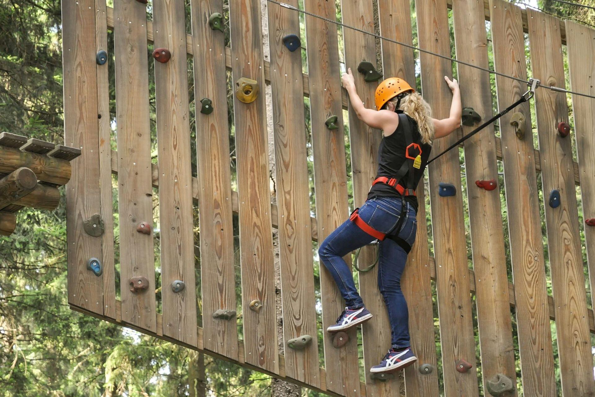 Climber wearing a harness and helmet on an artificial climbing wall