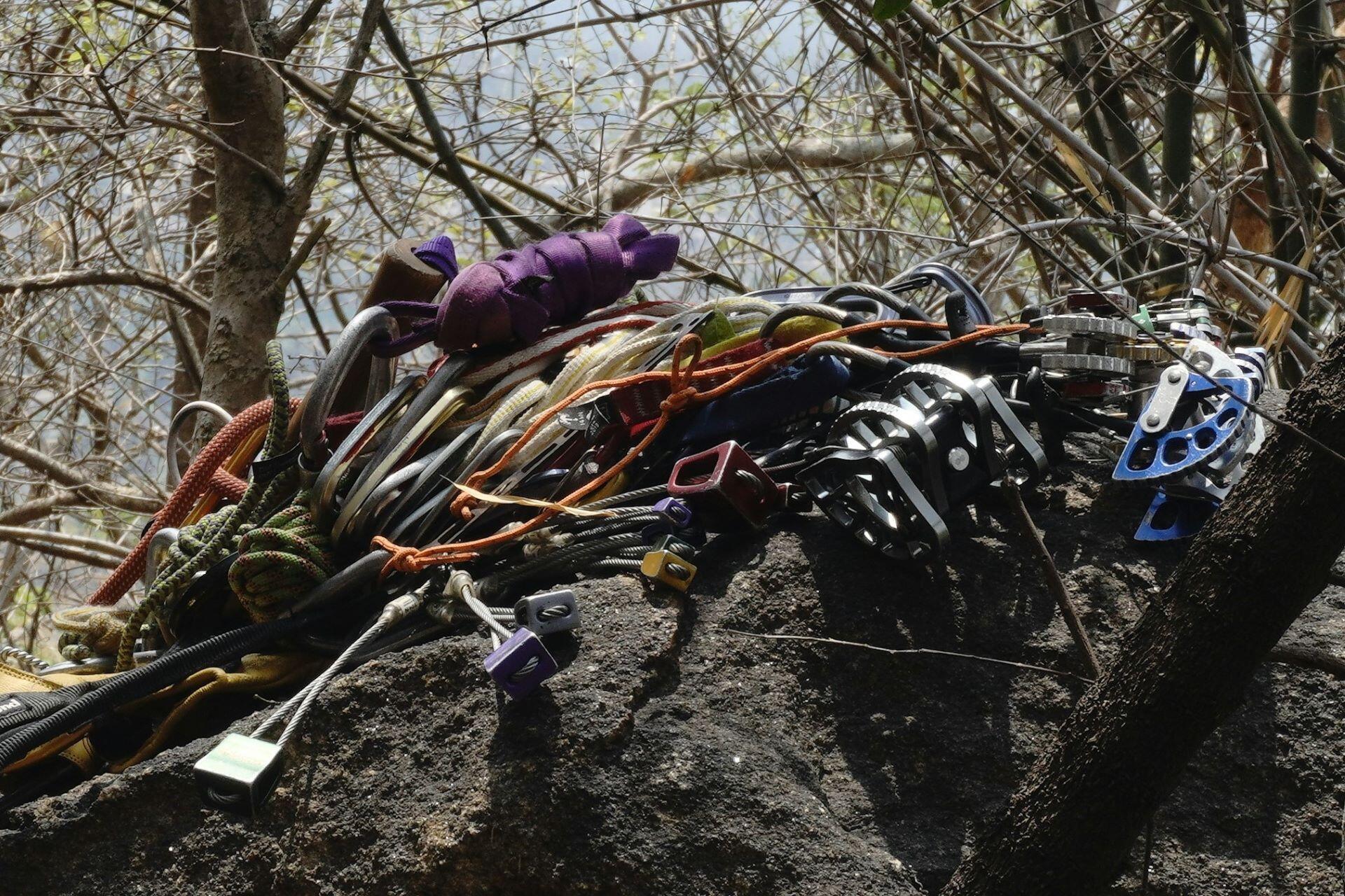 Climbing ropes, carabiners and protection equipment laid out on rock