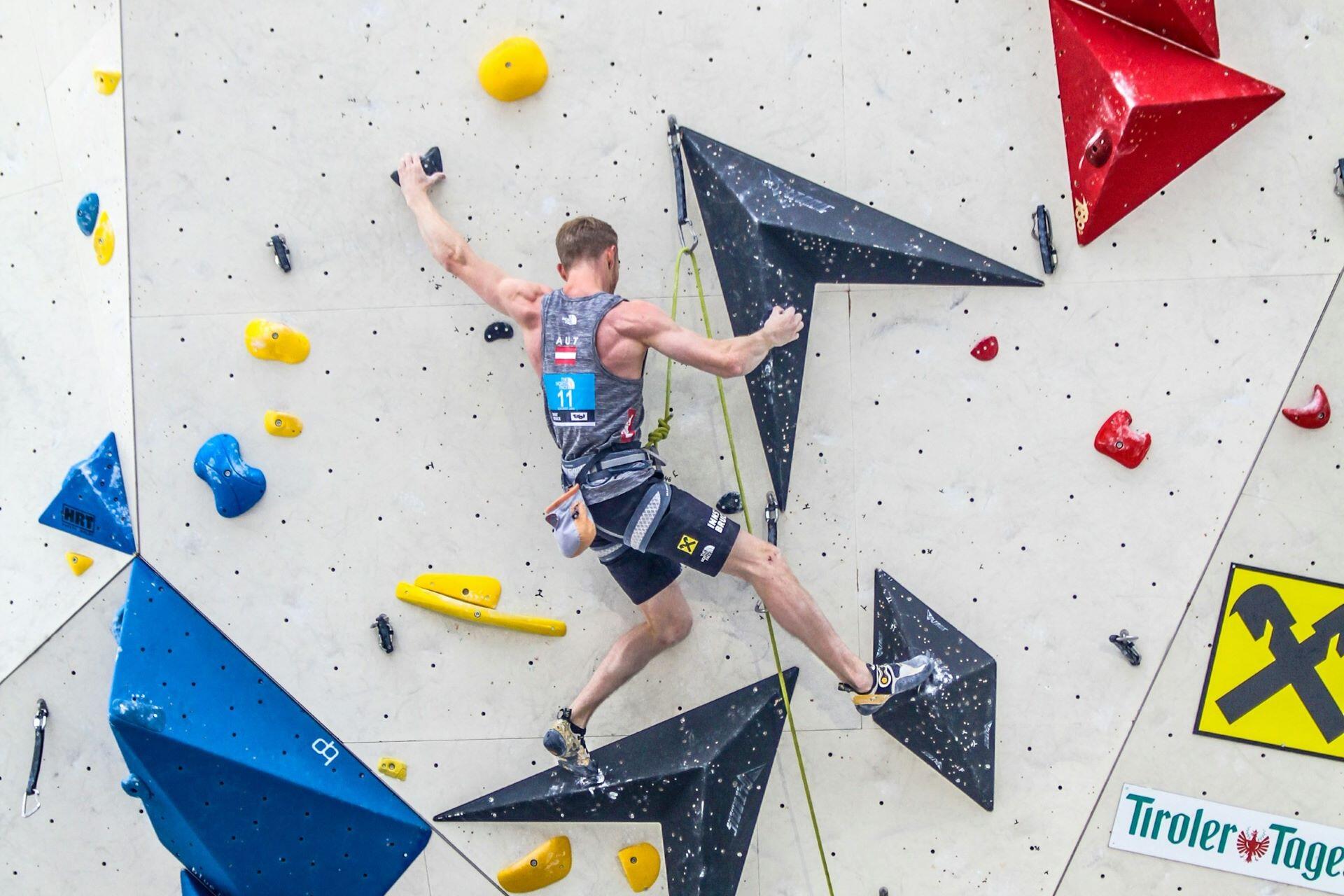 Competitive climber tackling a route on an indoor climbing wall
