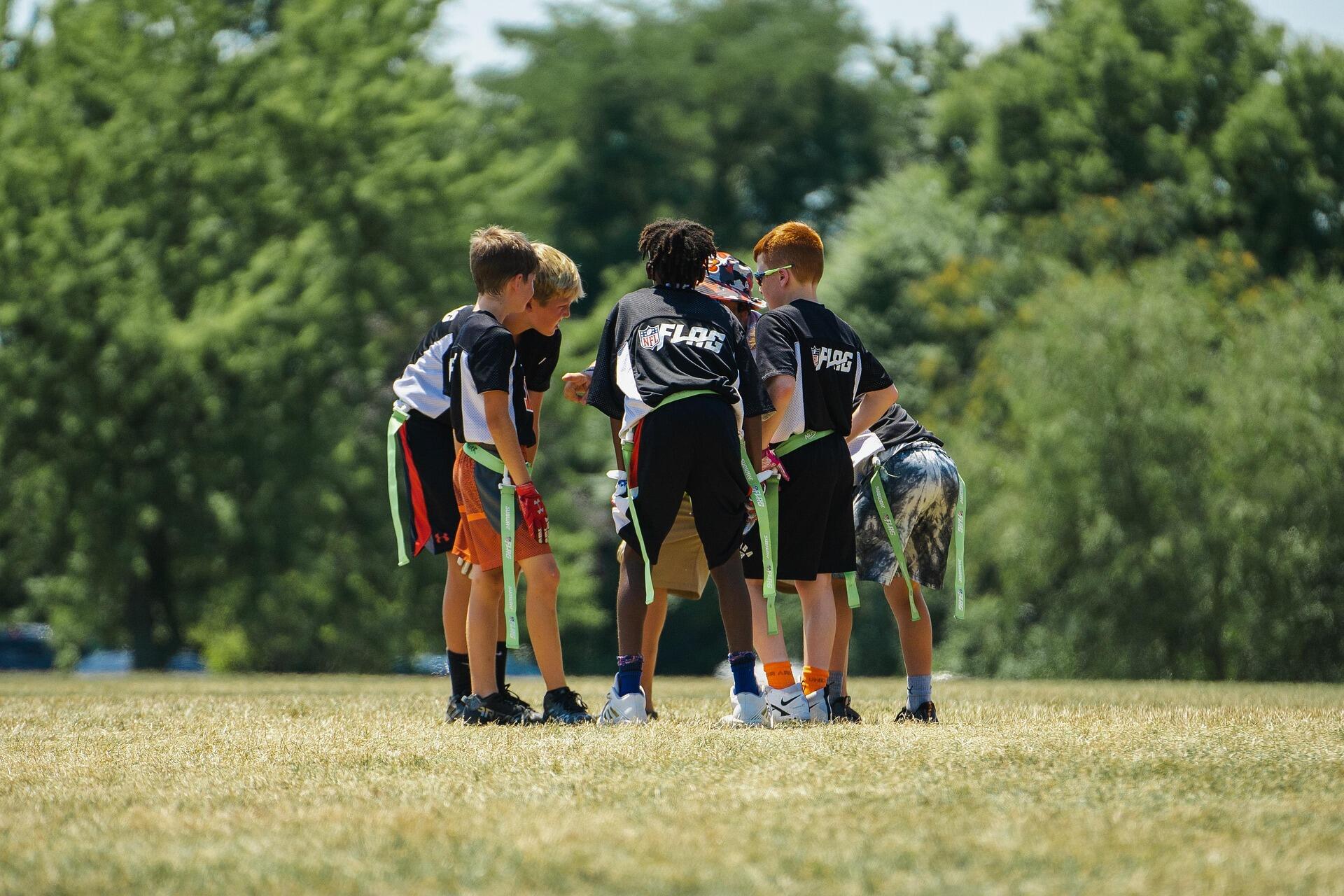 Youth flag football team huddle.