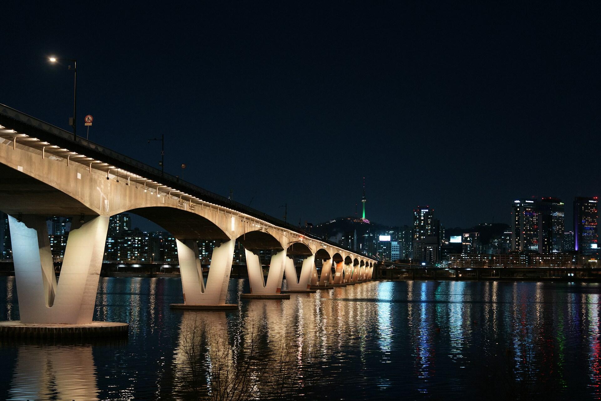 Illuminated bridge over the Han River with Seoul skyline at night