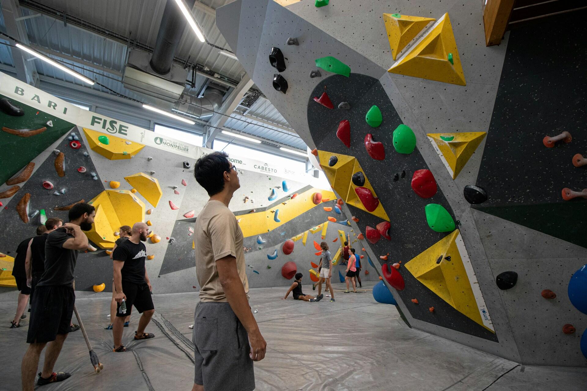 Climbers looking at routes inside a large indoor bouldering centre