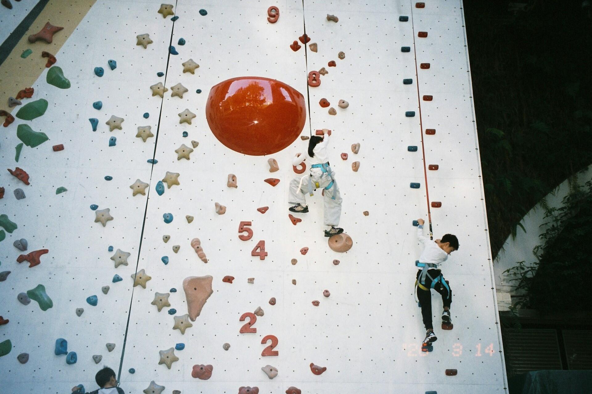 Children climbing on a colourful indoor climbing wall