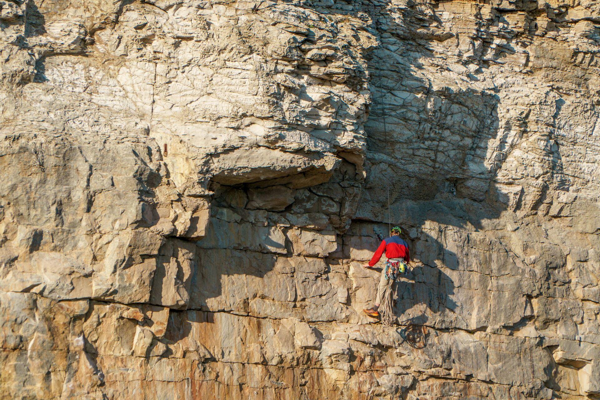 Roped climber ascending an outdoor rock face