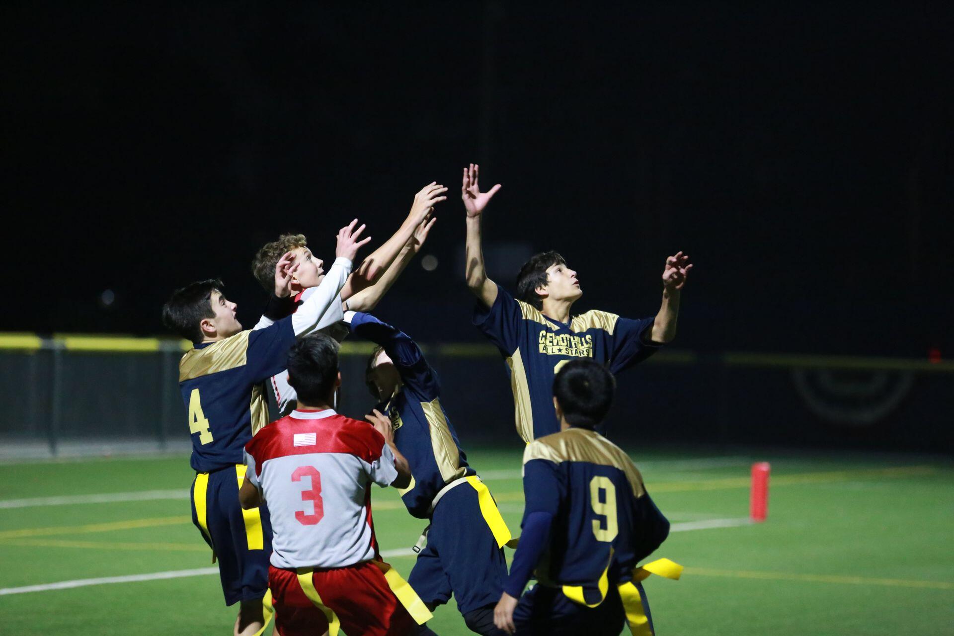 Young athletes fighting to catch a football.