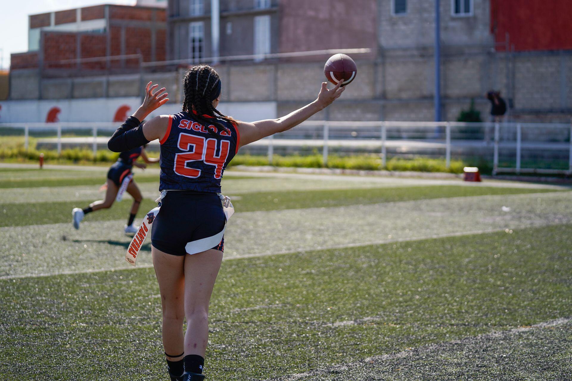 Female athlete catching a football.