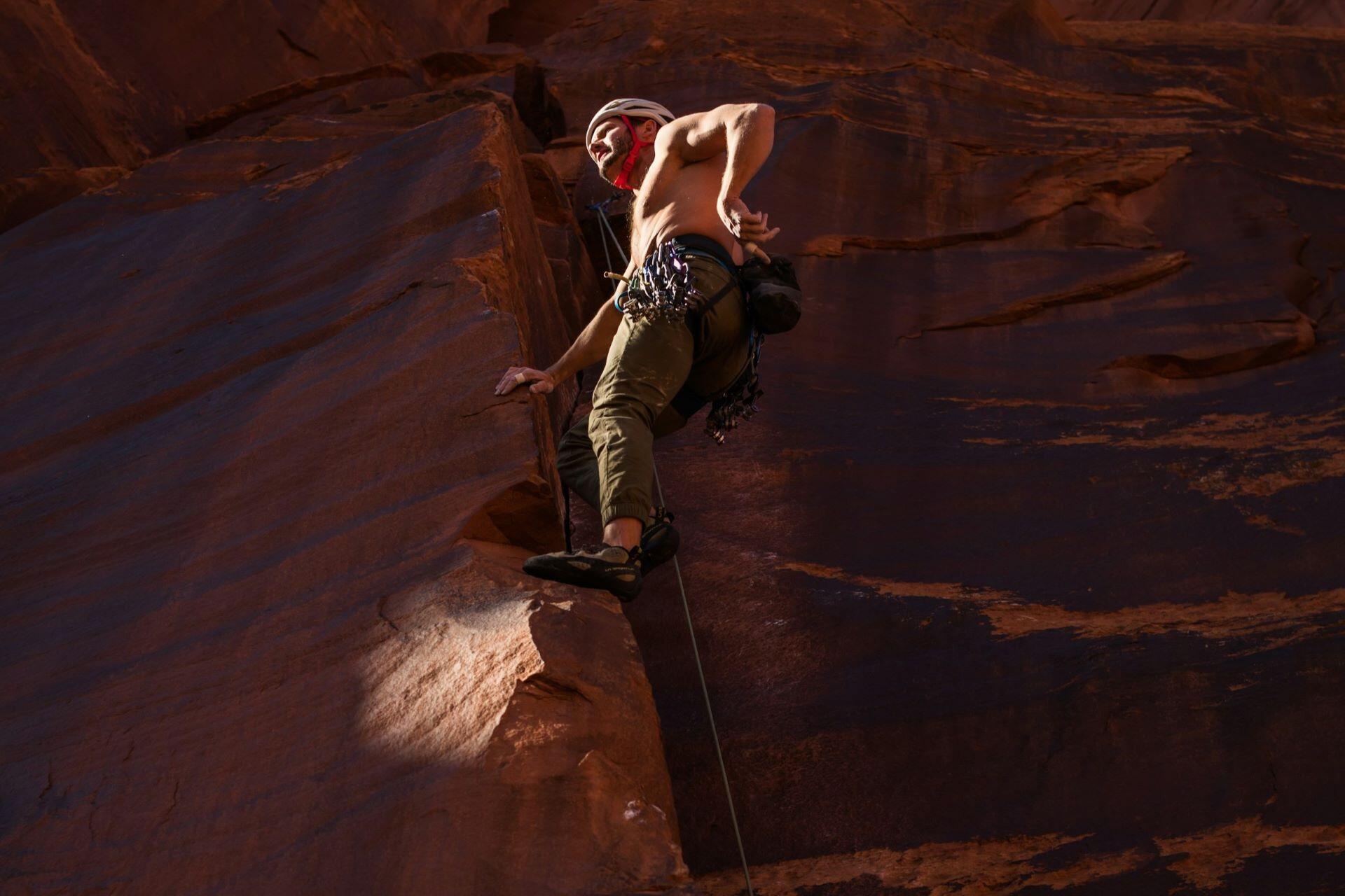 Rock climber ascending a steep outdoor rock face