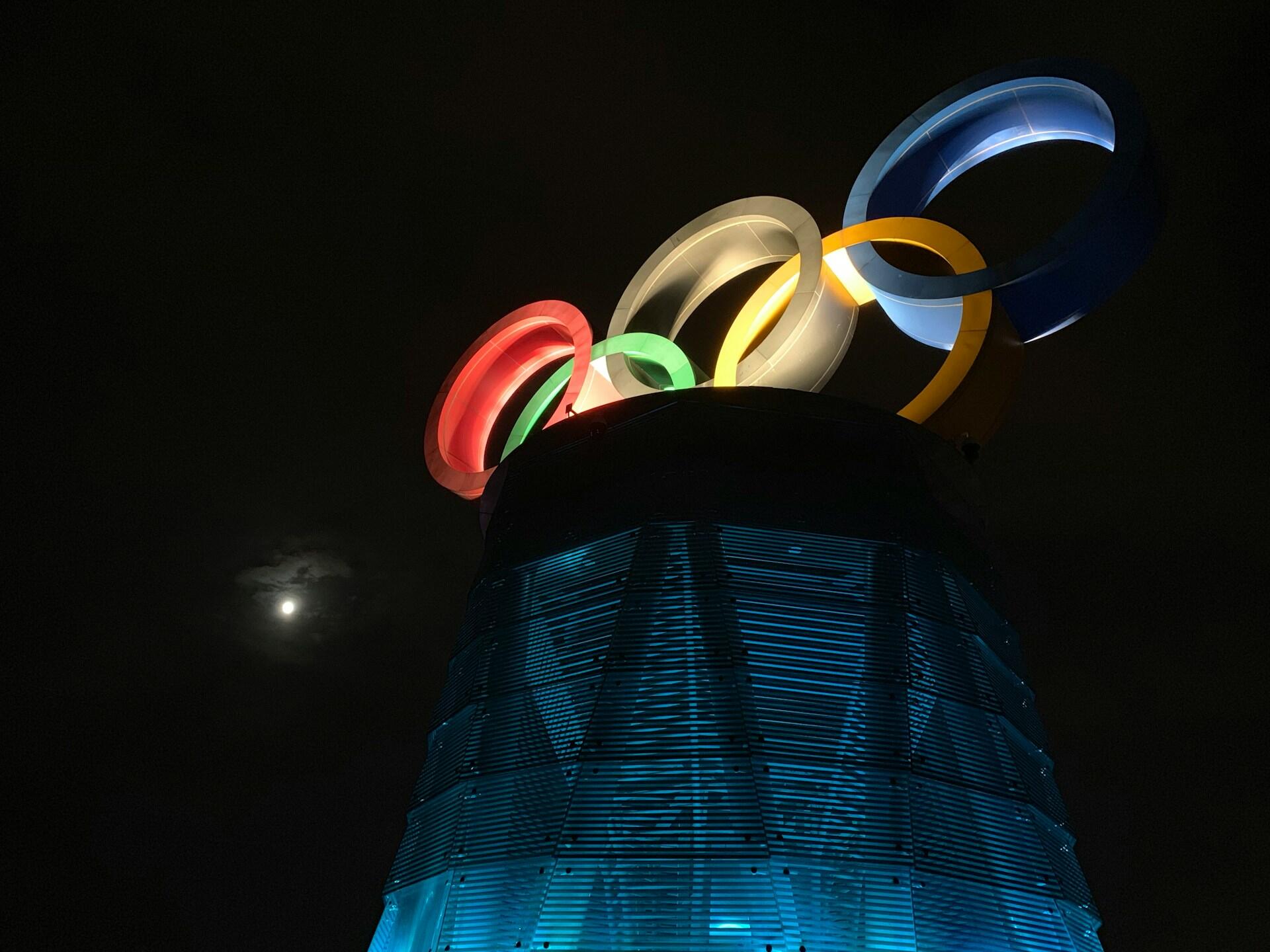 Olympic logo lighted up at night.