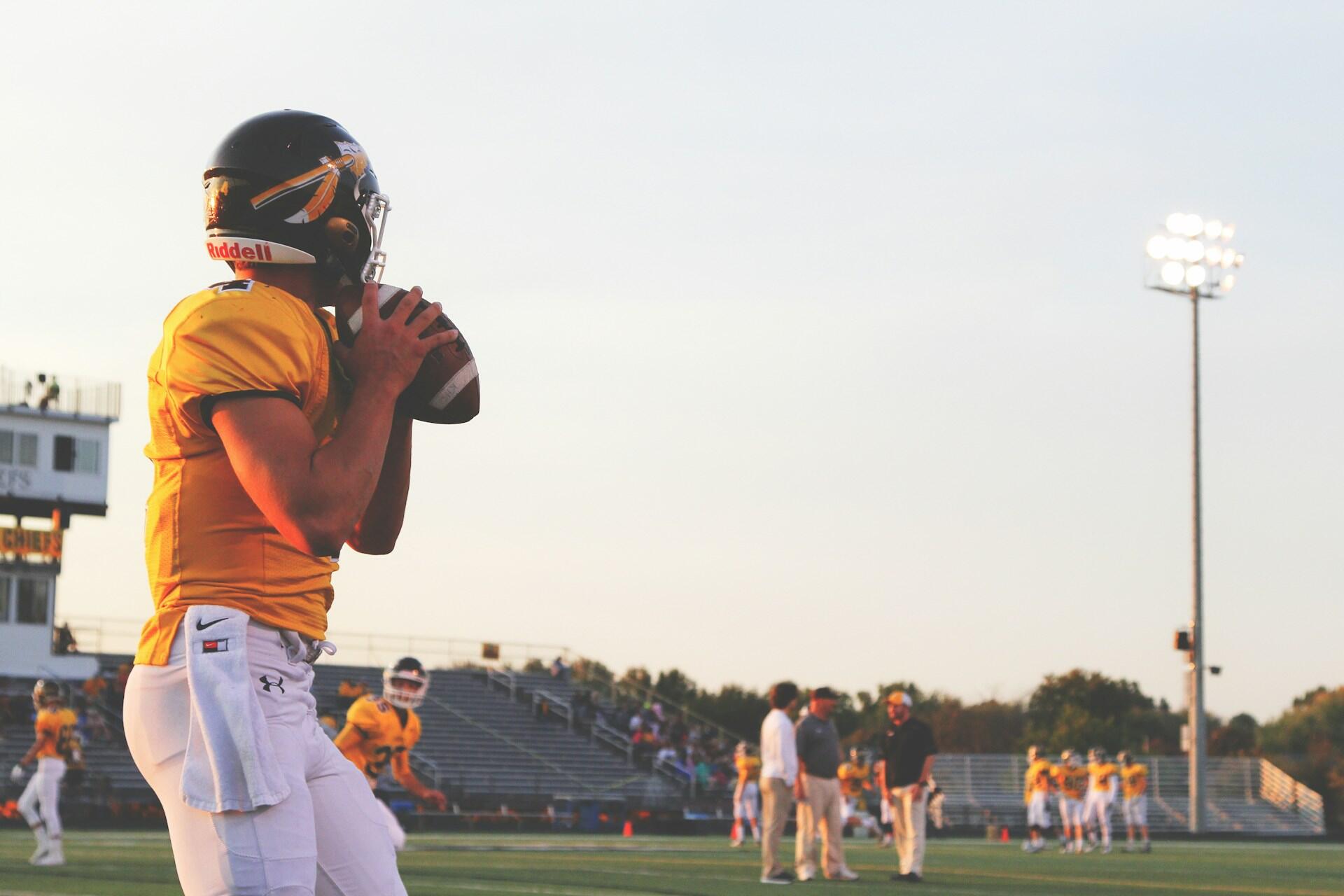 american football player about to throw a ball on a football field