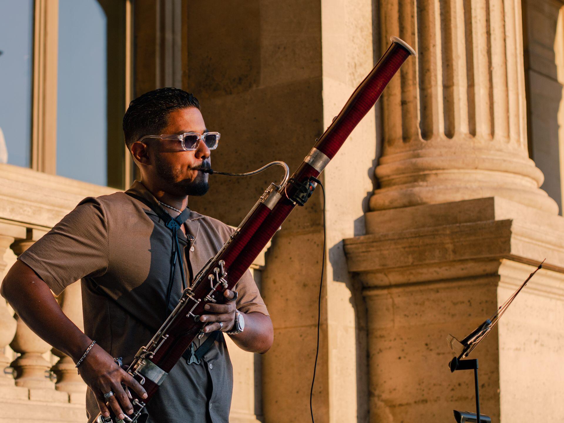 a bassoon player plays their instrument outdoors