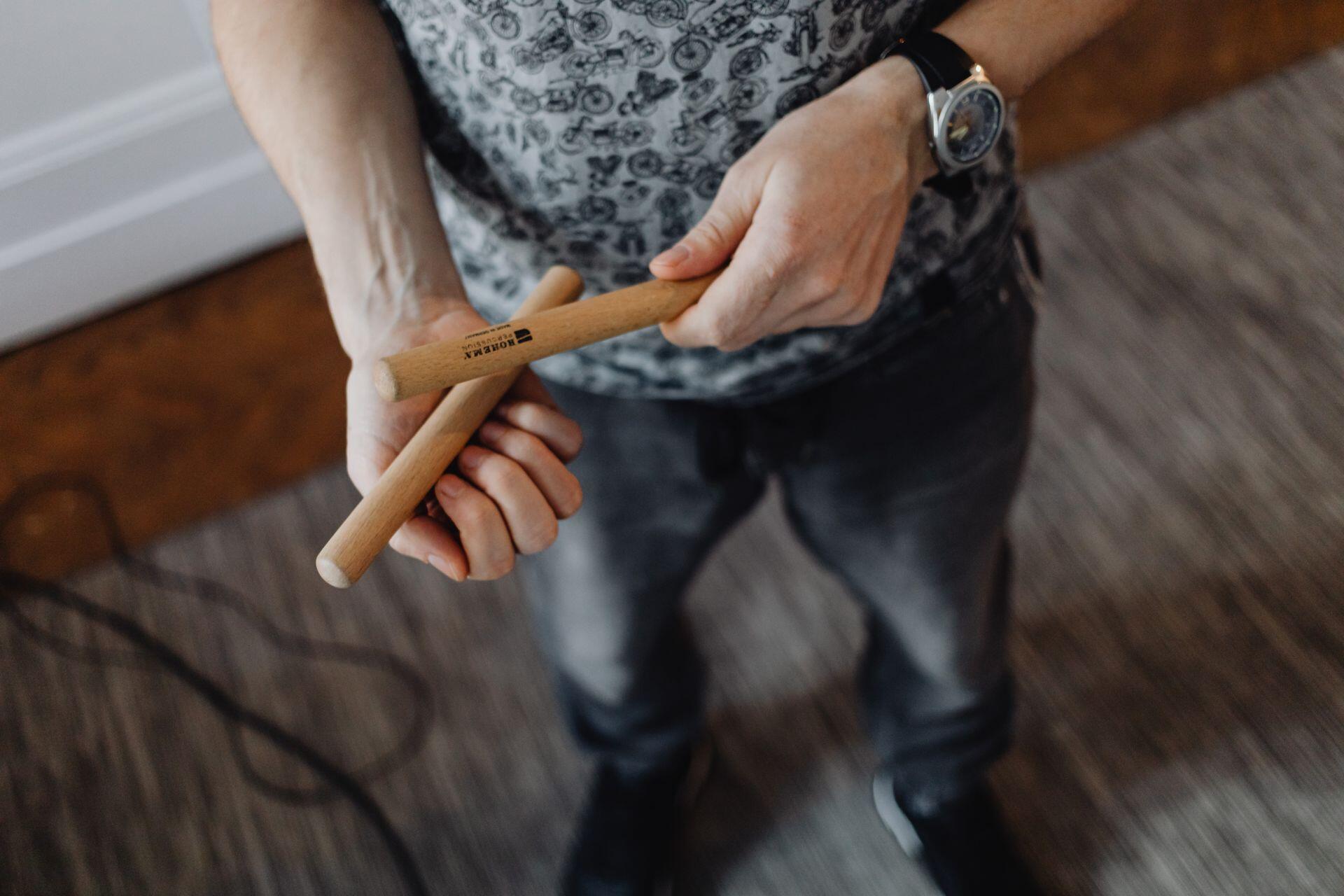 person holding claves, which are short wooden sticks that are hit together