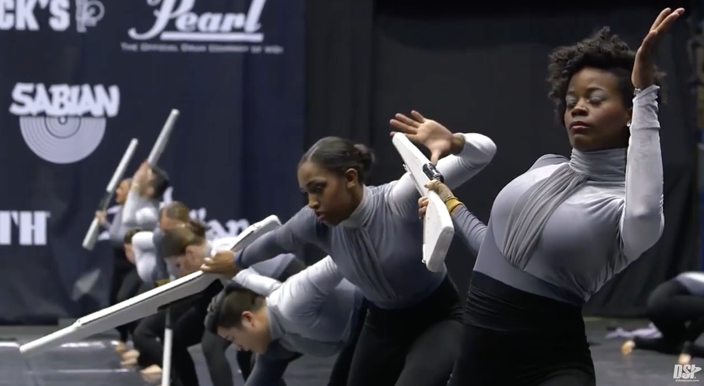 A team of winterguard color guard performers holding replica rifles as part of their routine