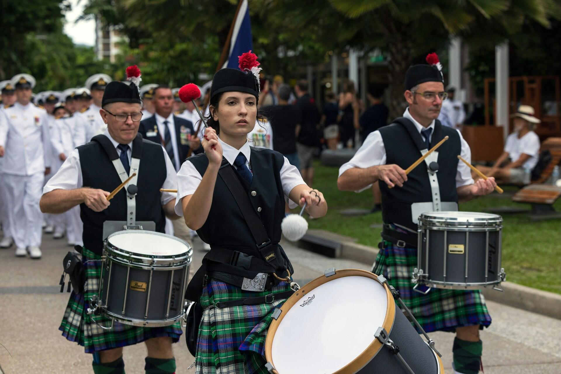 drummers in a Scottish band marching while playing