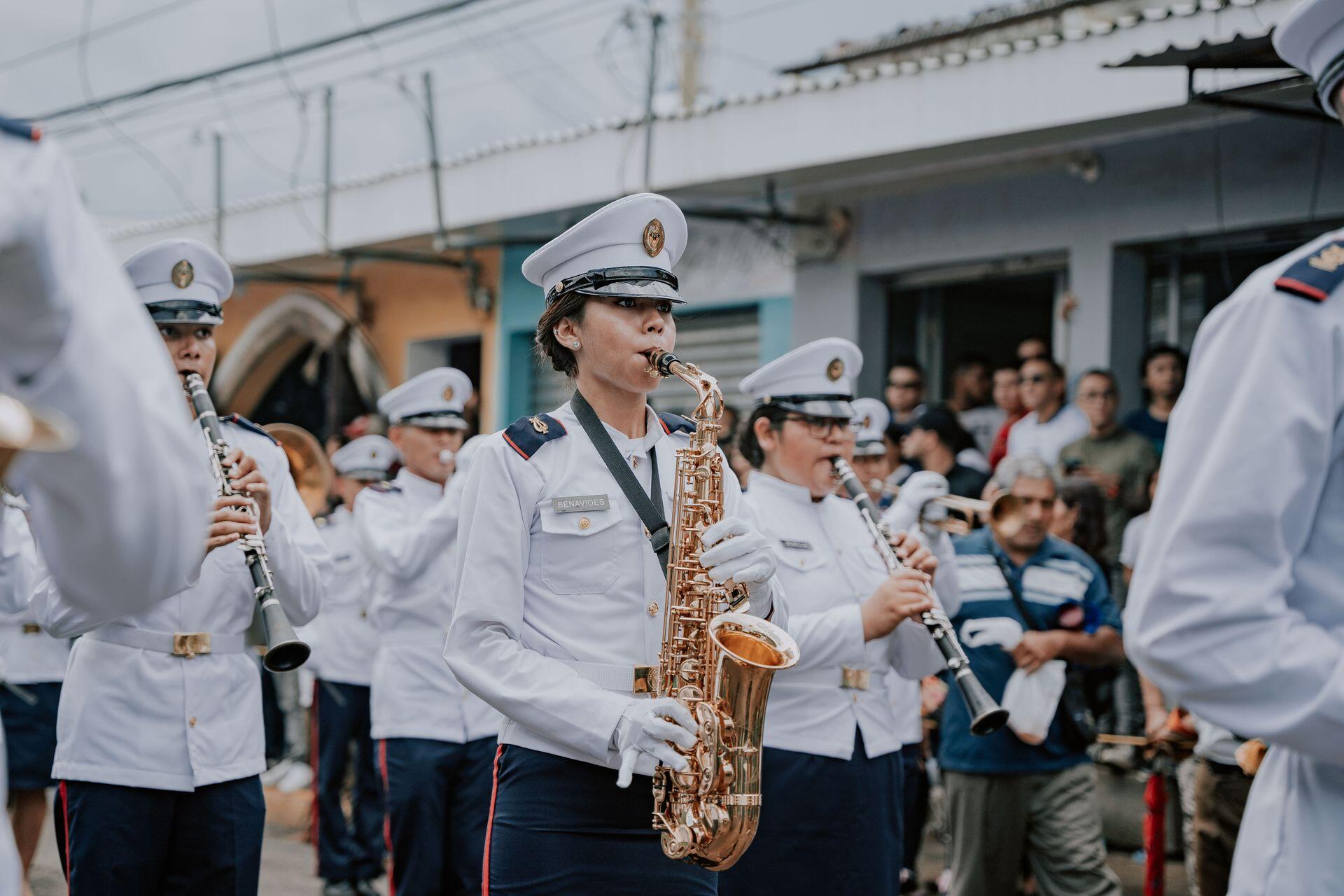 saxophone and clarinet players participating in marching band, wearing uniforms and standing in formation