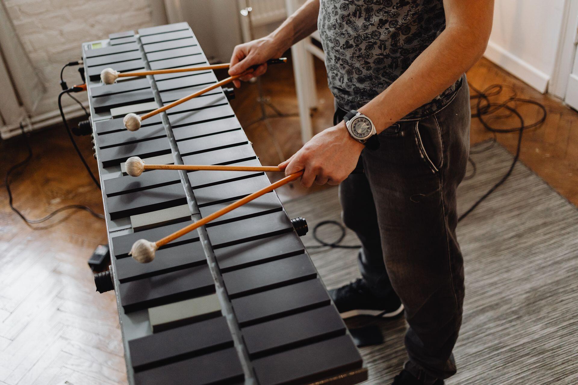 musician playing an electric marimba with two drumsticks in each hand