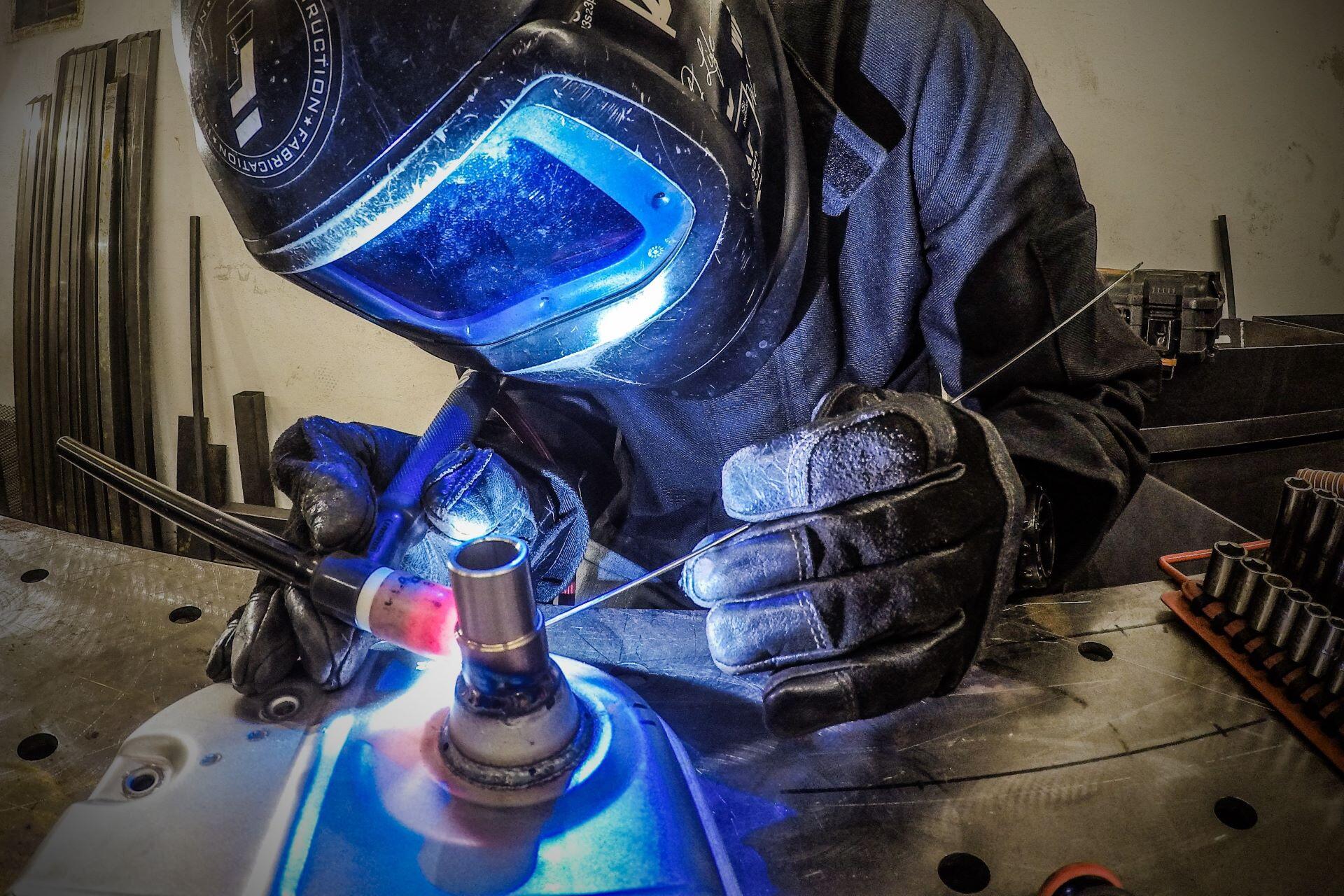 Welder using a TIG torch on metal tubing