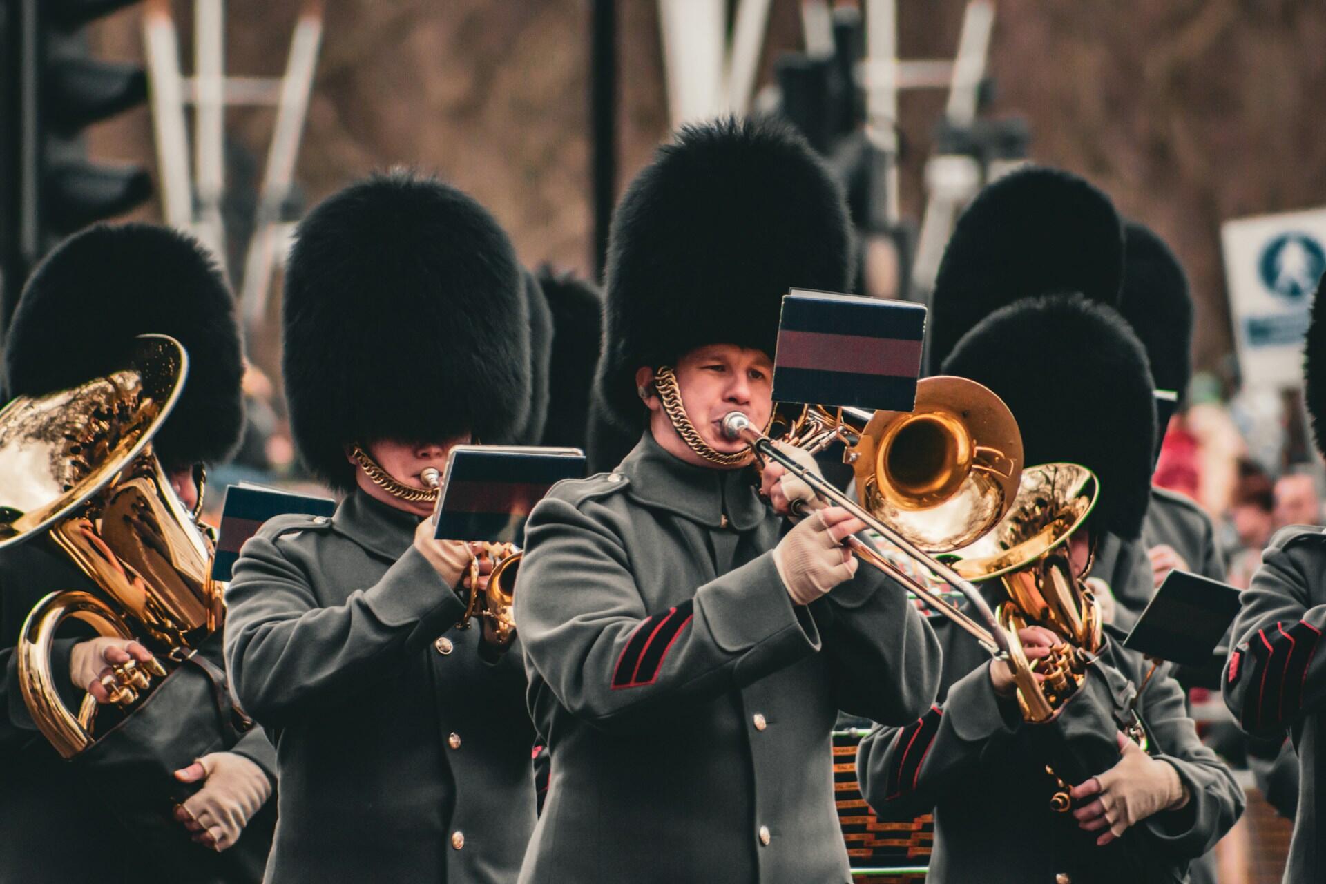 uniformed marchers playing various brass instruments in a marching band