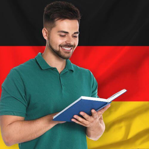 Άντρας στέκεται μπροστά από την γερμανική σημαία και διαβάζει βιβλίο.