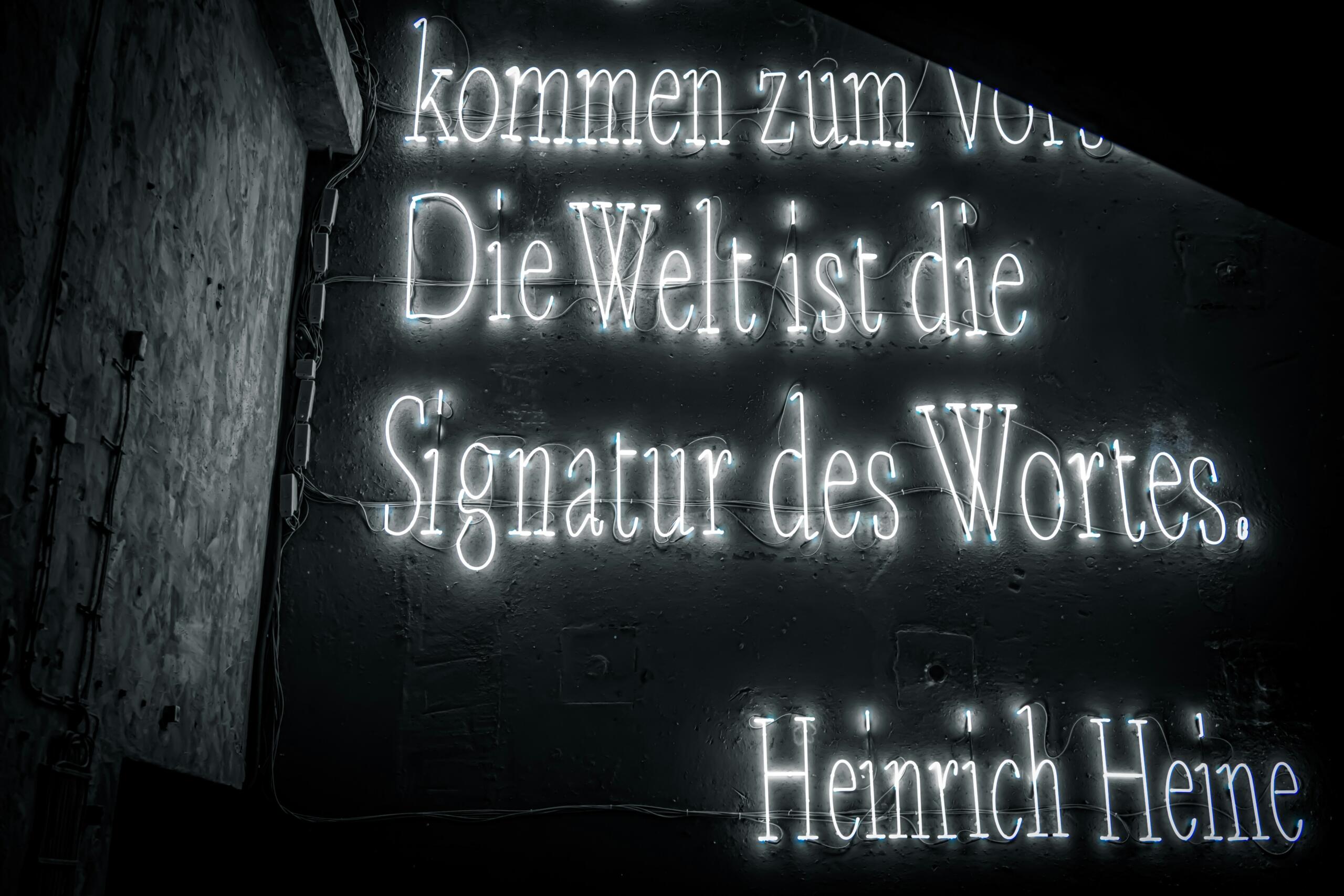 Νέον επιγραφή με την γερμανική φράση  "Die Welt ist die Signatur des Wortes".