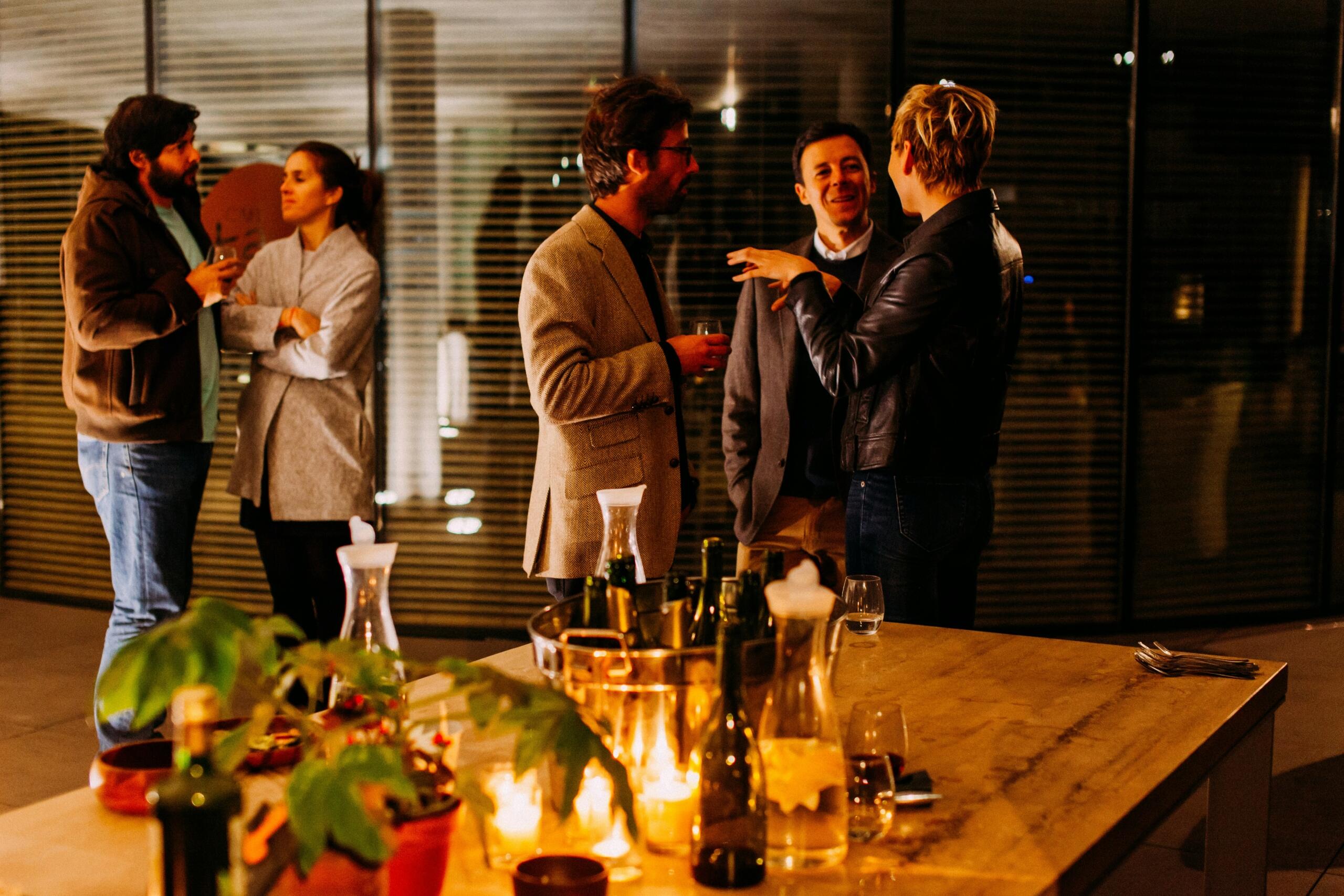 Συνάδελφοι συζητούν και κάνουν networking σε επαγγελματική βραδινή εκδήλωση.