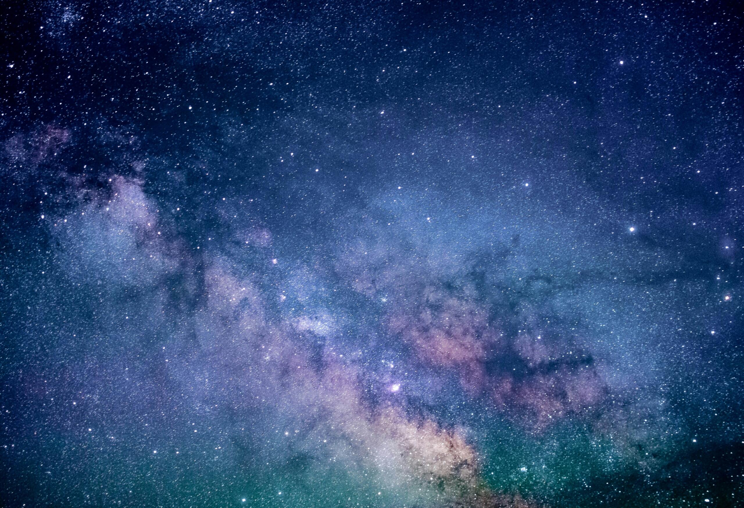Ο Γαλαξίας του Milky Way φωτίζει τον νυχτερινό ουρανό με χιλιάδες αστέρια και αποχρώσεις του μπλε και του μωβ.