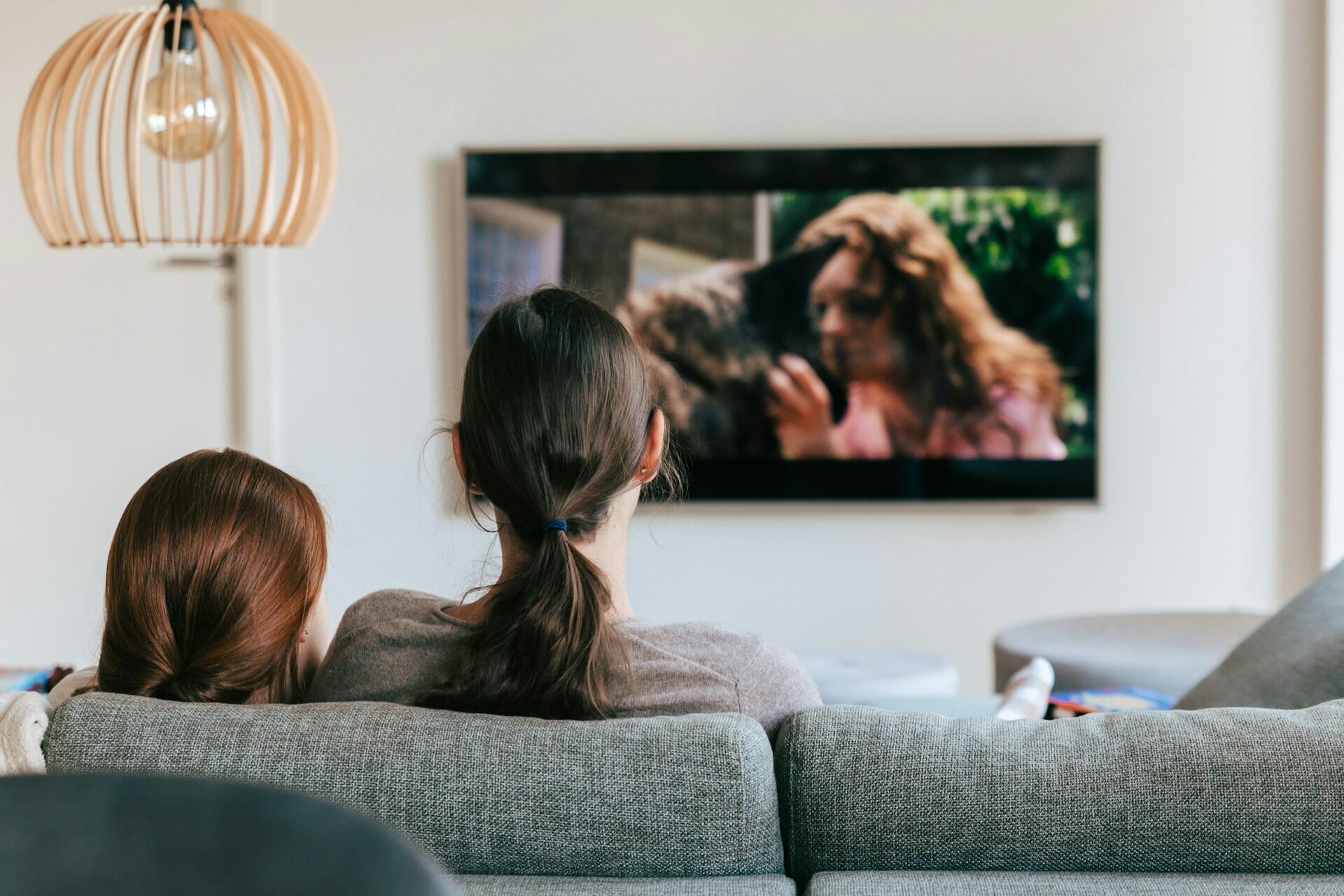 2 osobe gledaju TV