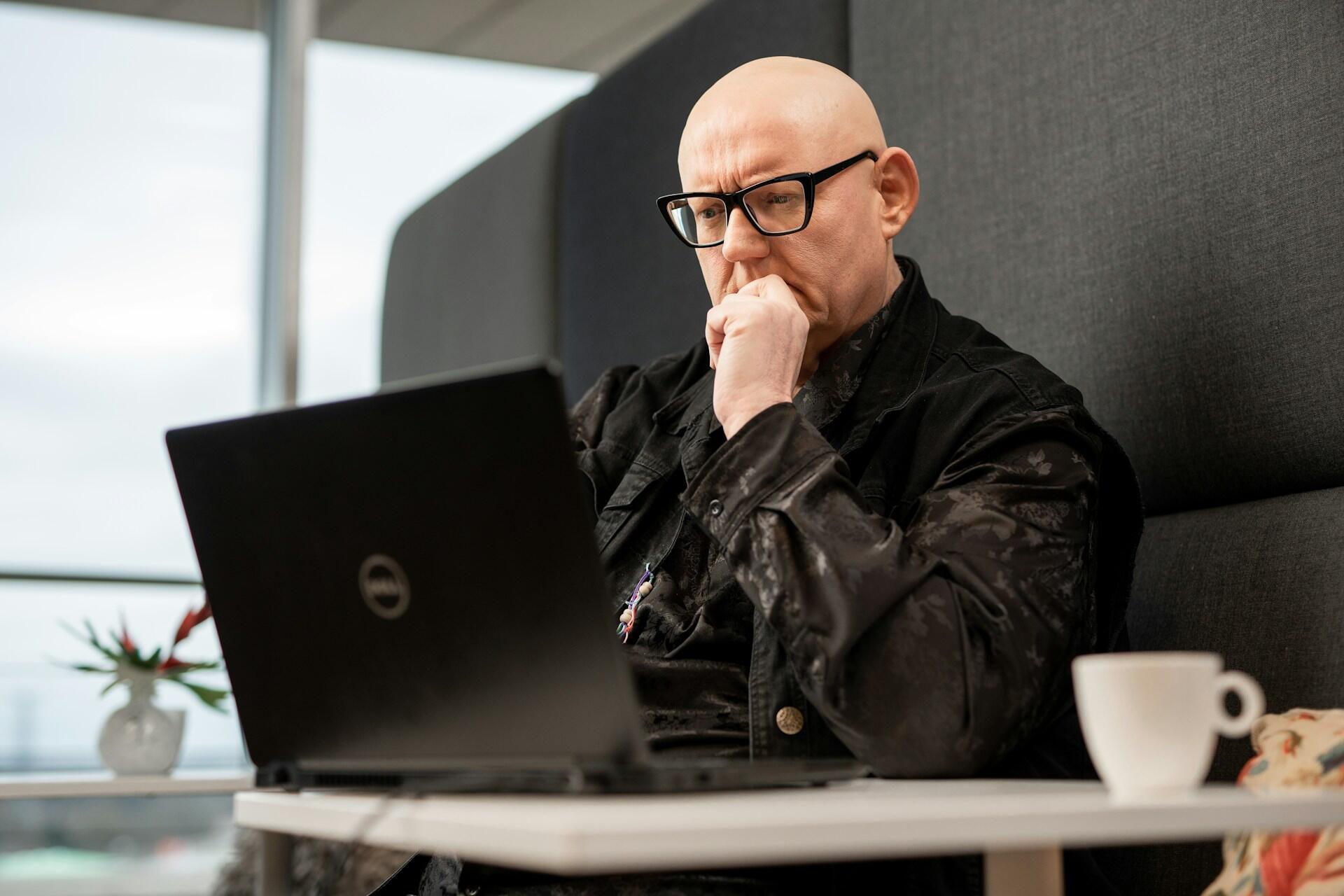 kopasz férfi laptop előtt
