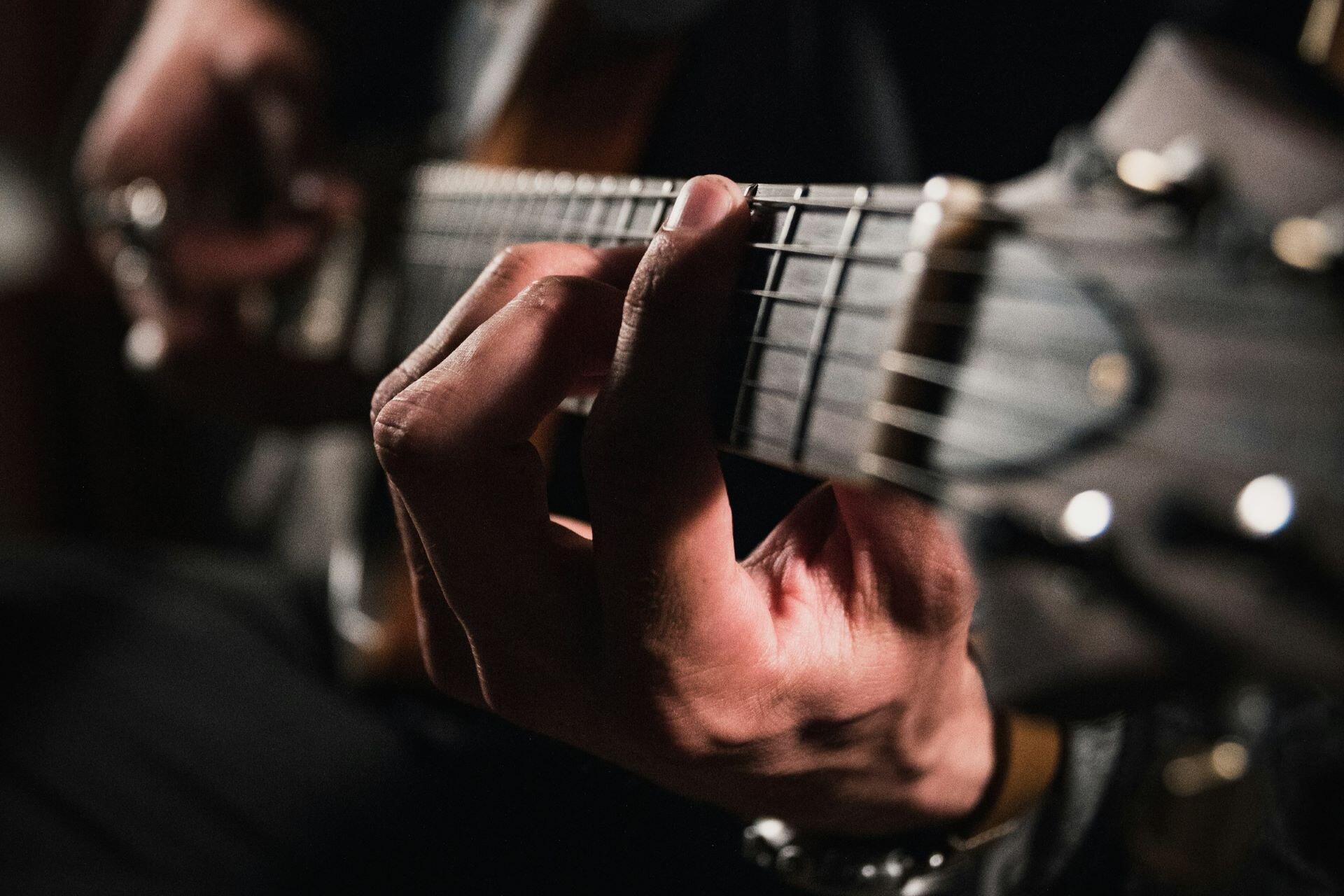 Close-up of a guitarist forming a chord on an electric guitar