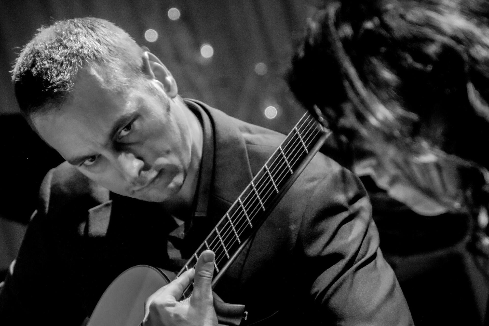 Guitarist demonstrating finger placement during a lesson
