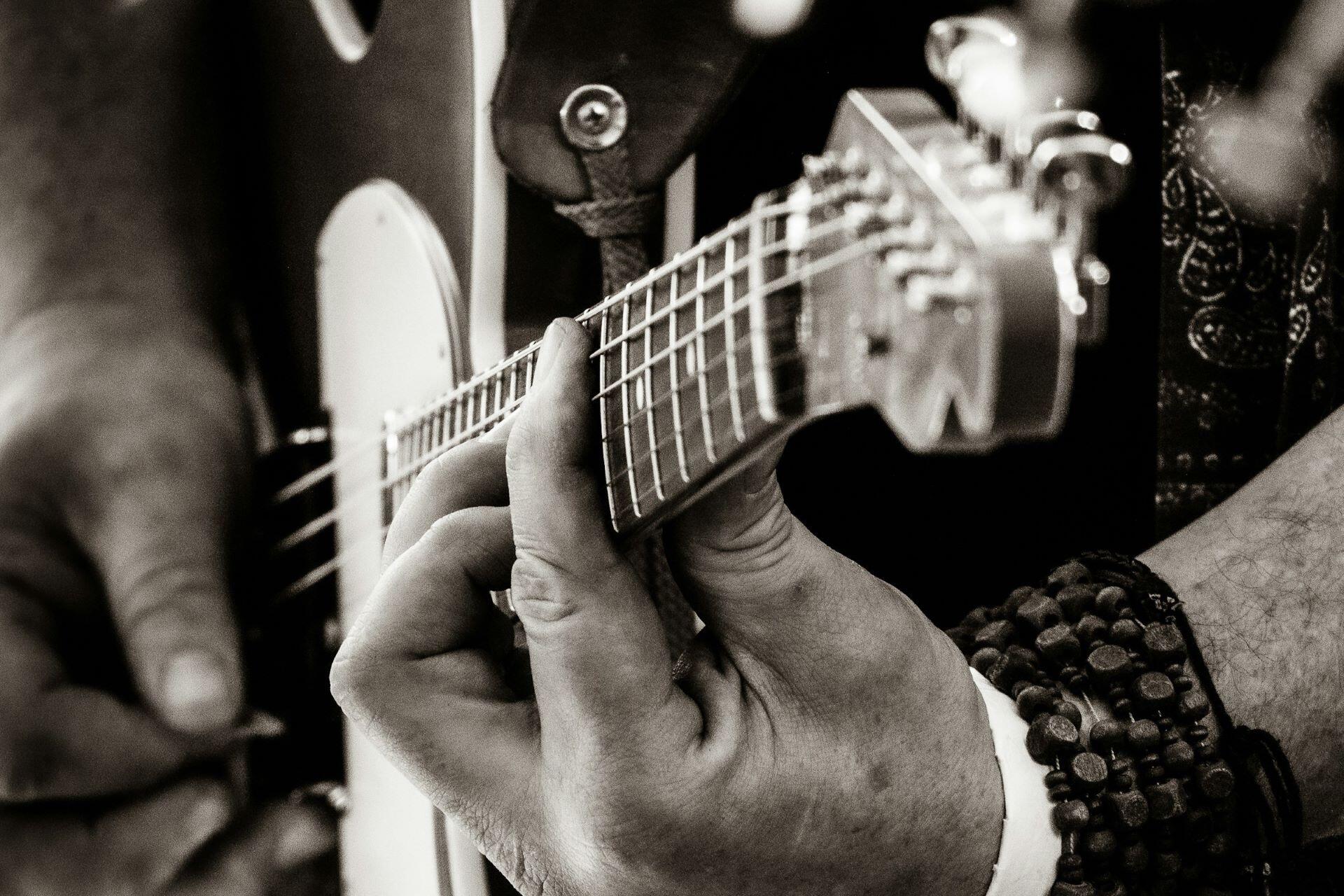 Close-up of fingers pressing the strings on an electric guitar