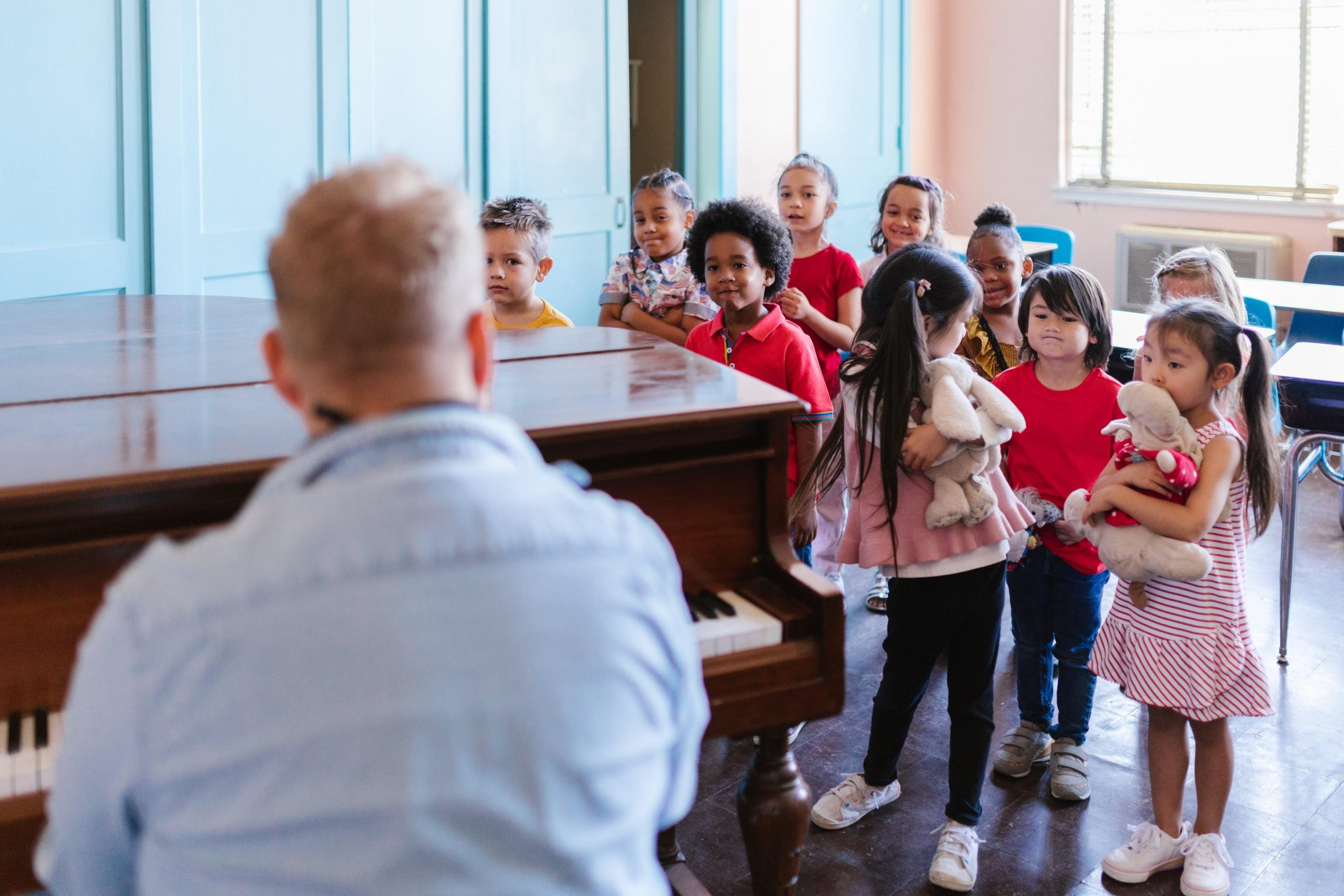 A piano teacher playing in front of his students