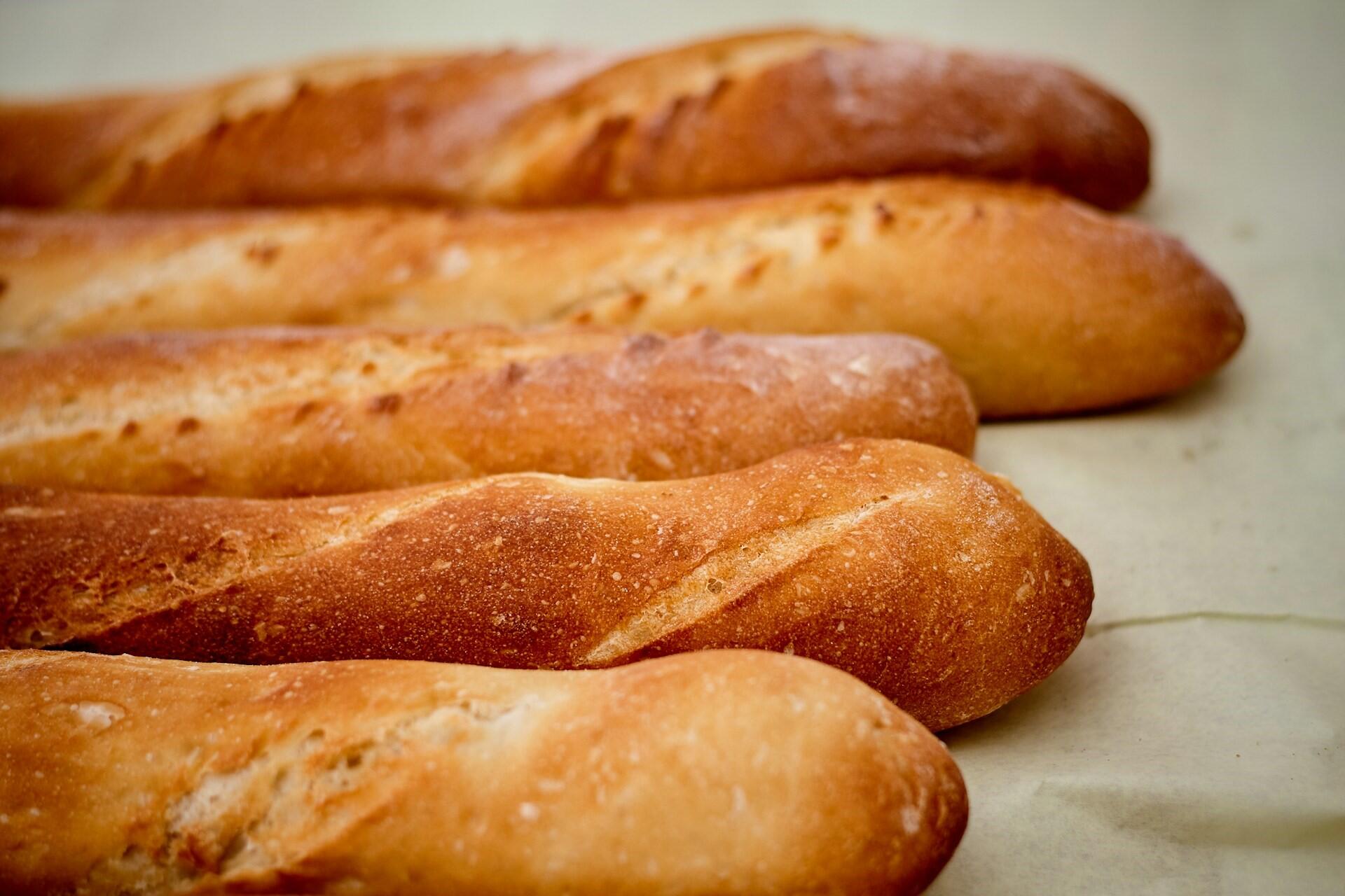 Fresh baguettes arranged on a bakery counter