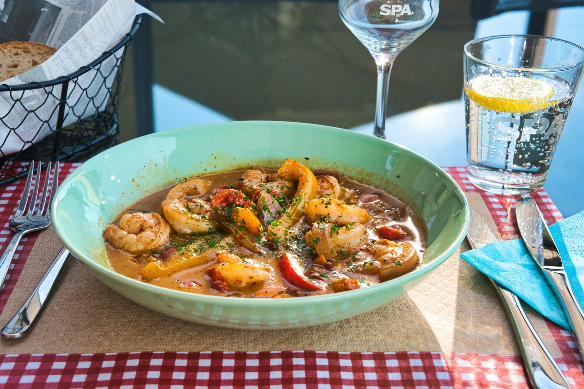 Bowl of seafood stew with prawns, peppers and herbs