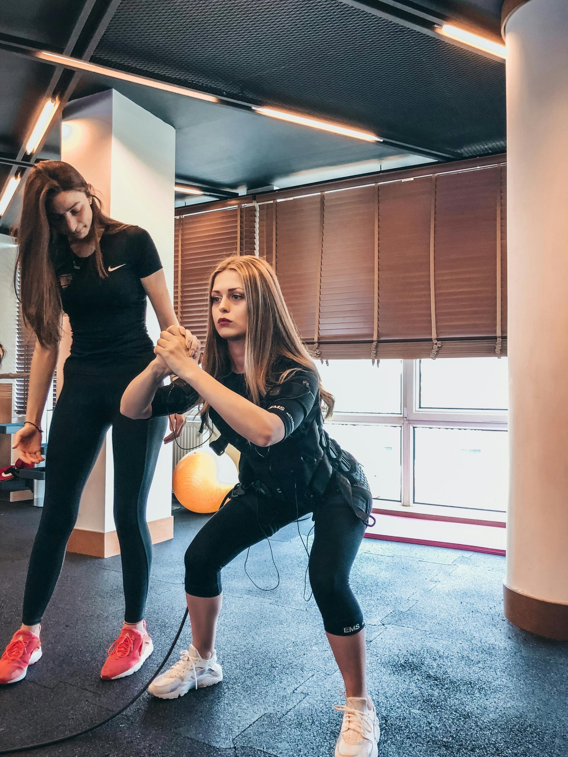 A personal trainer working one-to-one with her client at the gym