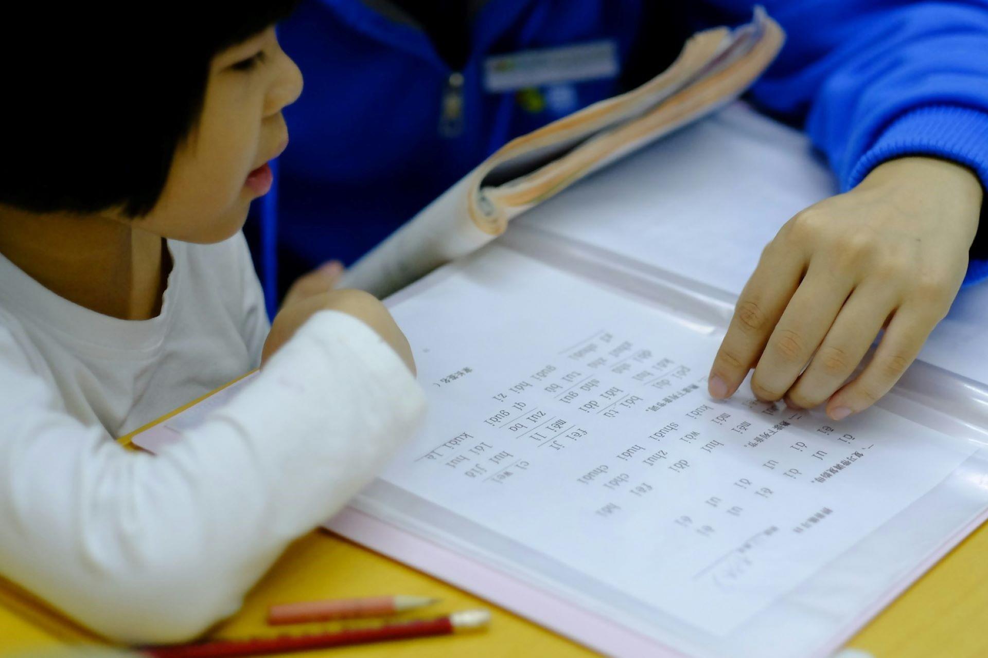 A child studying with a n adult.
