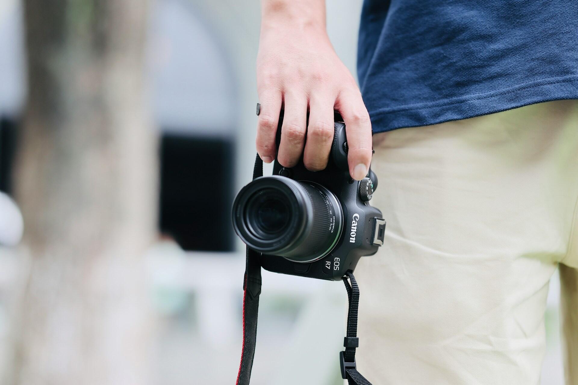 A person holding a Canon EOS R7.