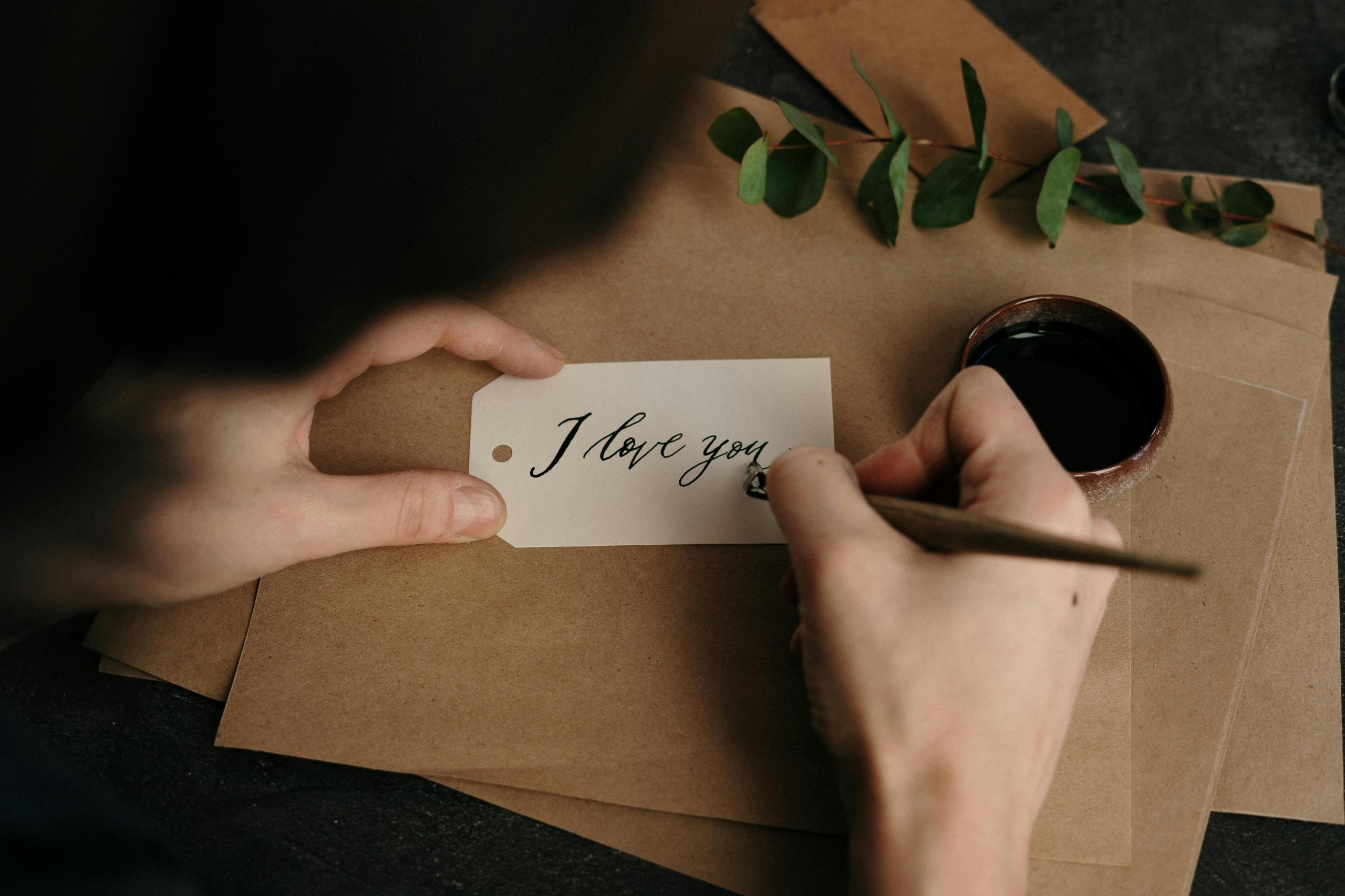 He expresses his love by writing the three words and eight letters beautifully.