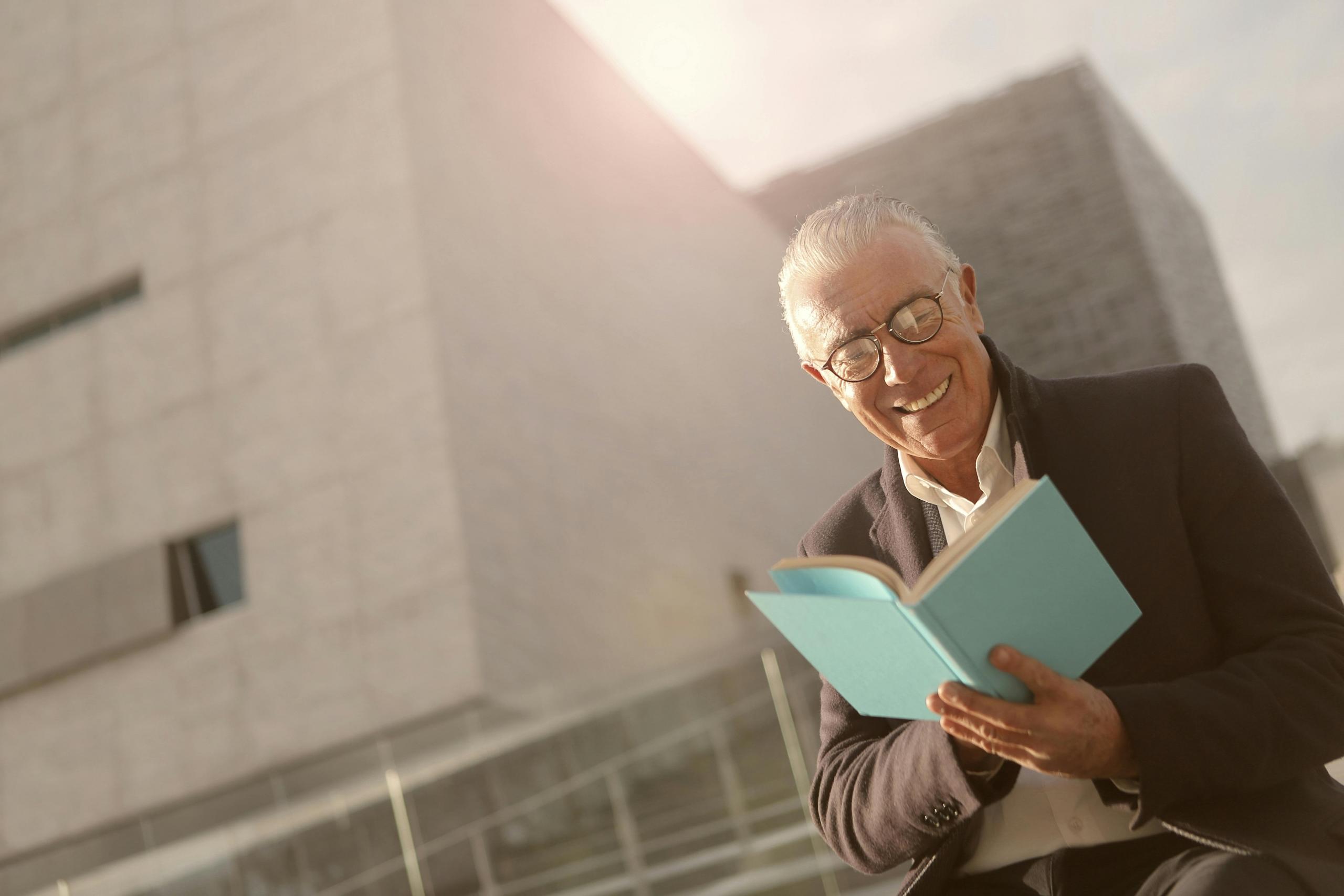 A man enjoying the punchline of a limerick he is reading in a poetry book