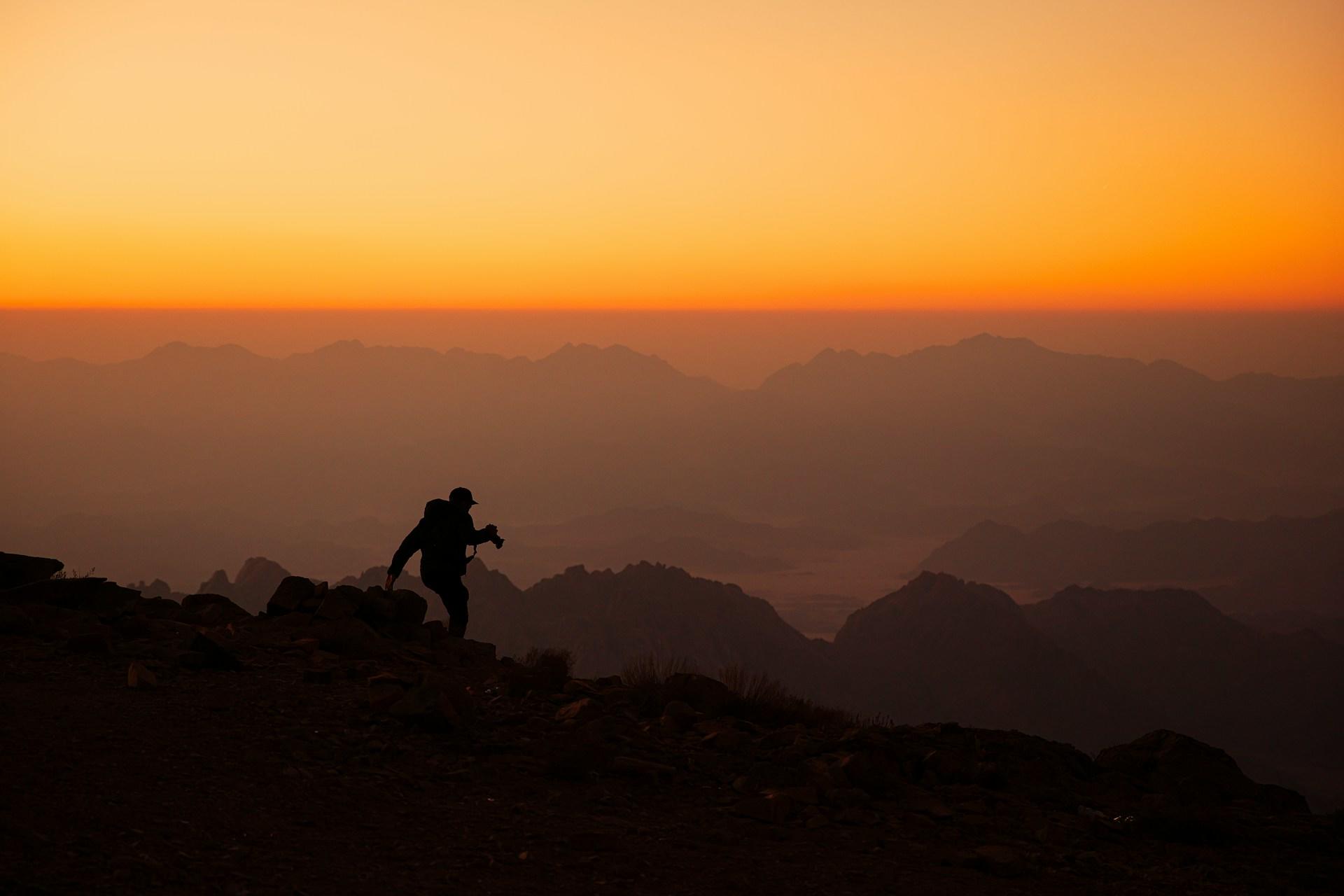 A person hiking in the mountains at sunset.