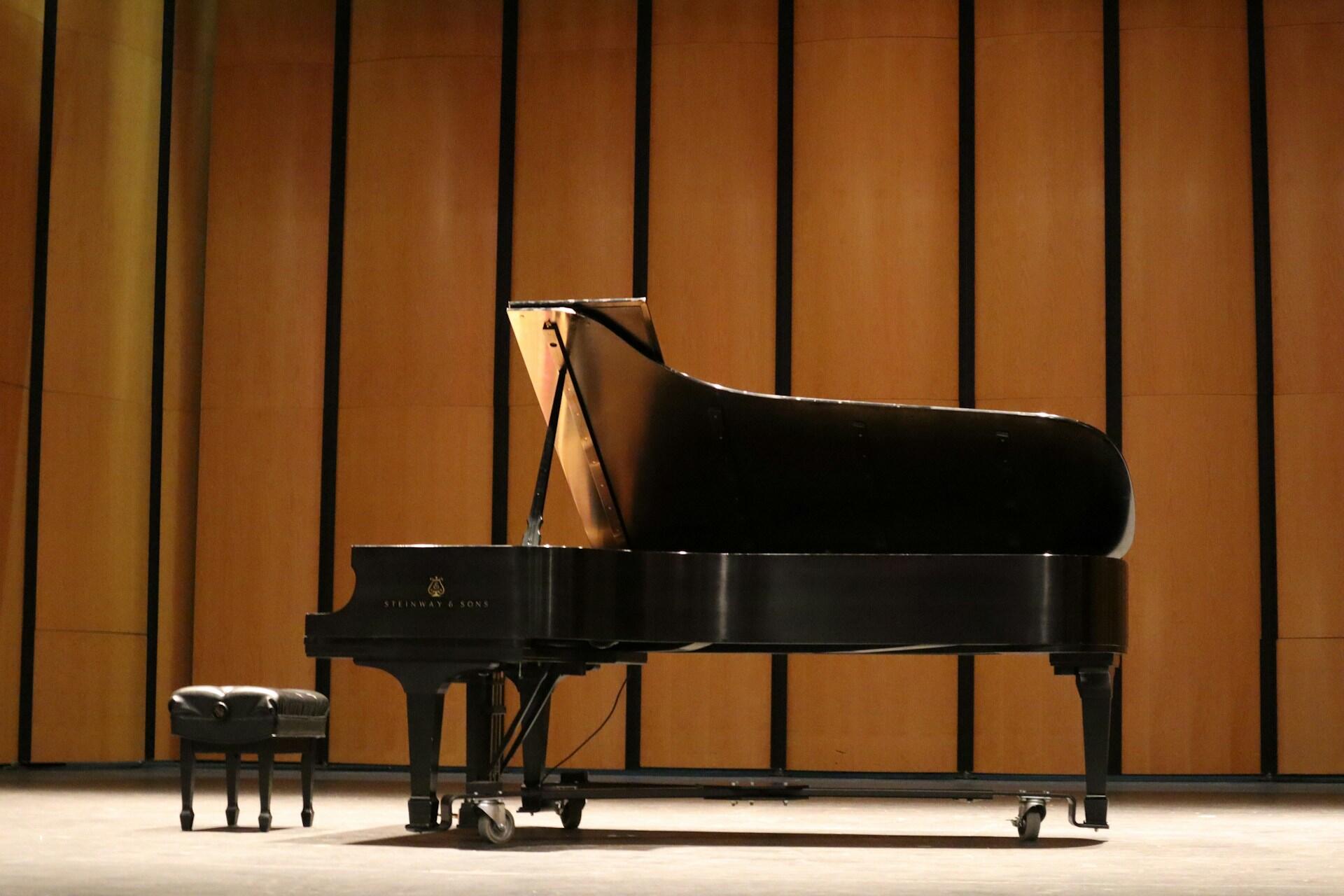 A grand piano in a performance space.