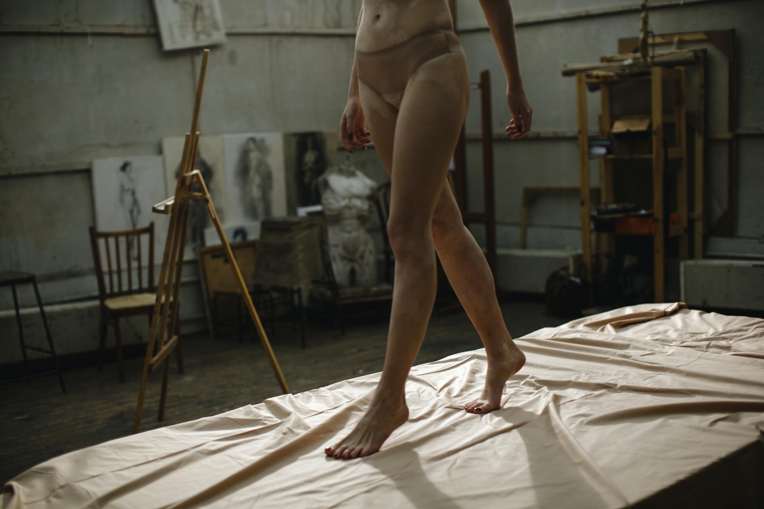 A life model walking and posing during a session.