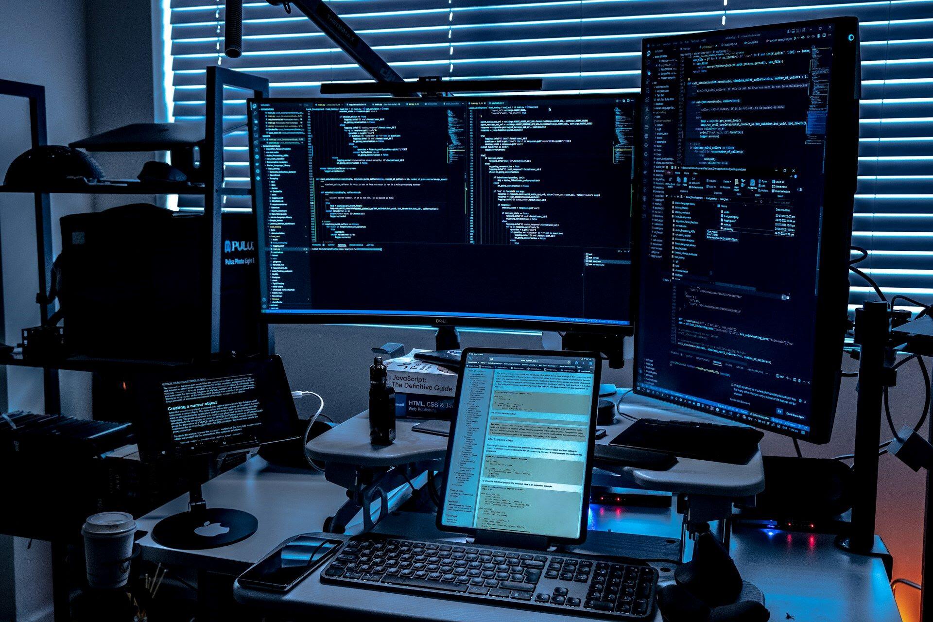 computer setup with multiple monitors displaying code and development tools