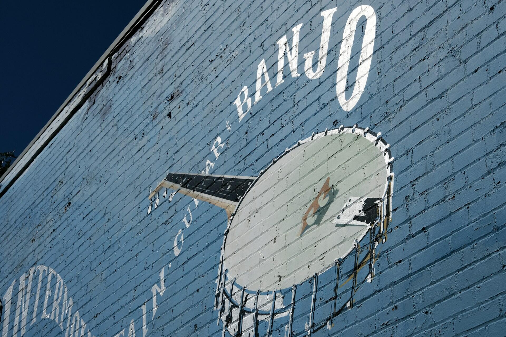 mural painting of a banjo on a building wall