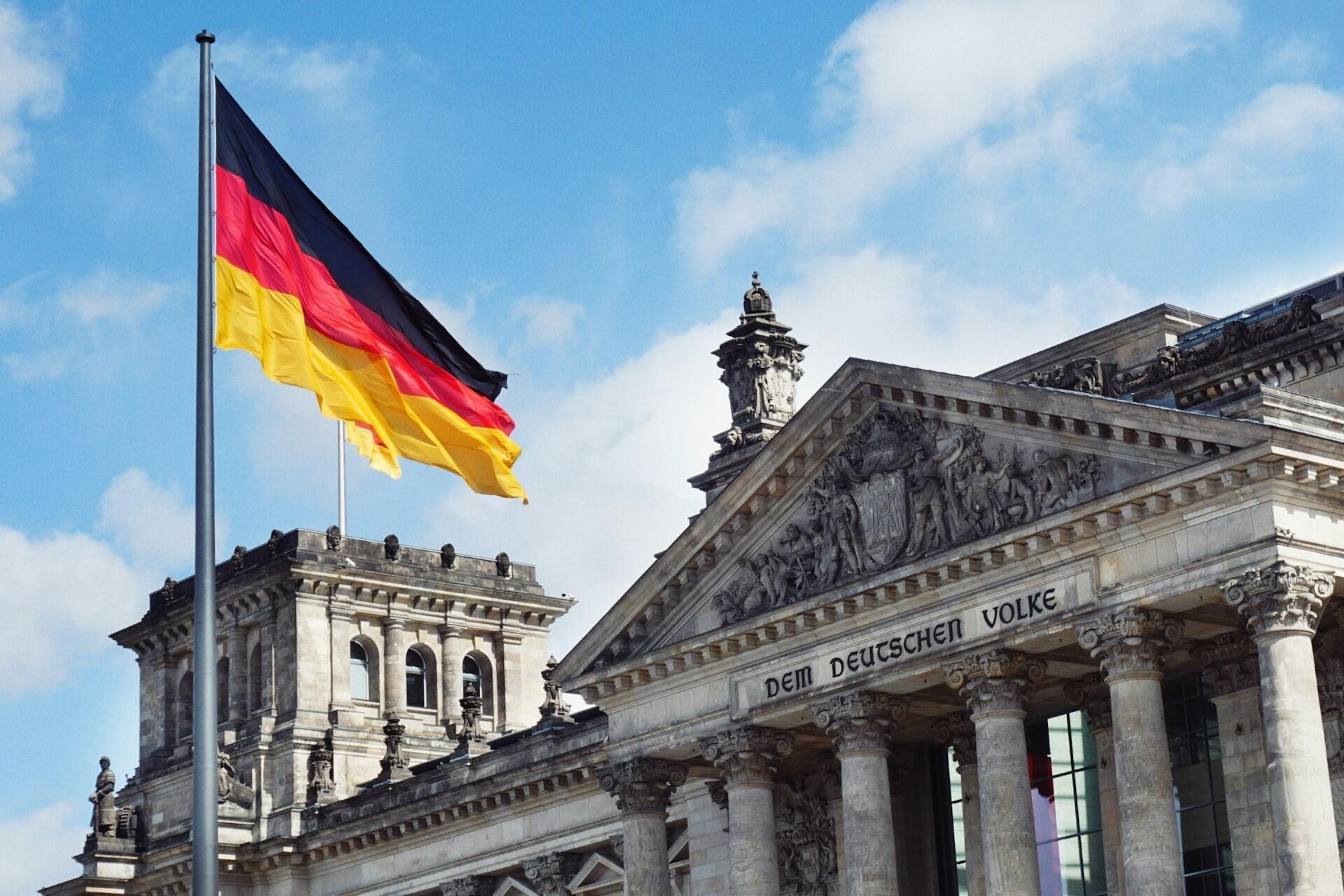 German flag flying in front of a historic government building